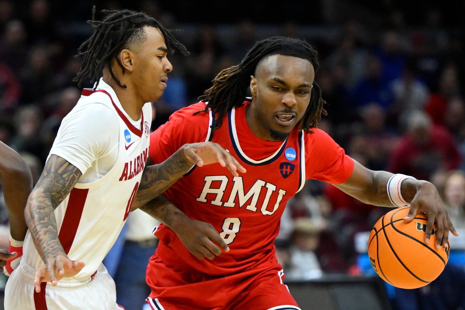 Alabama guard Labaron Philon, left, against Robert Morris guard Kam Woods (8) in the first half in the first round of the NCAA college basketball tournament, Friday, March 21, 2025, in Cleveland. (AP Photo/David Richard)