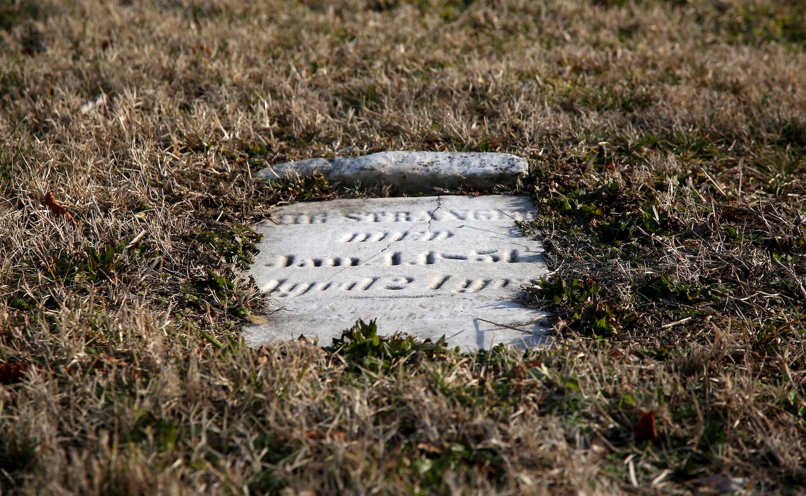 A tombstone labeled “THE STRANGER” marks the grave of a young woman buried at Old Greencastle Cemetery in Dayton. LISA POWELL / STAFF