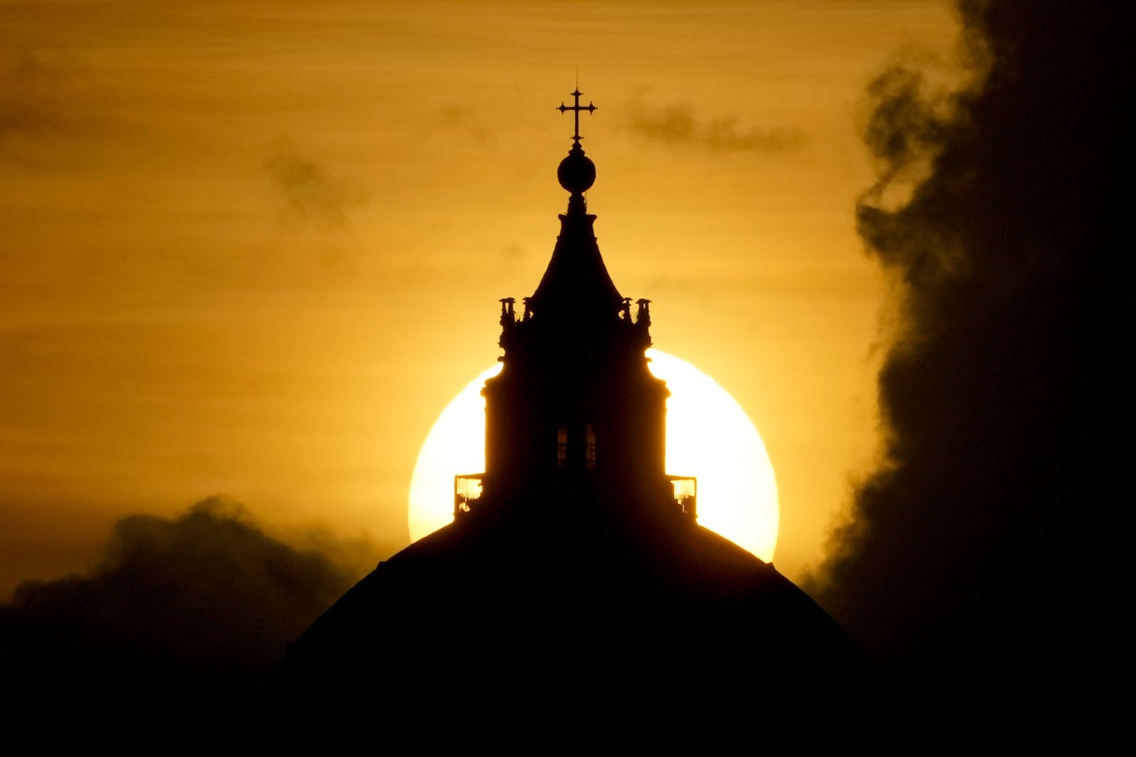 The sun sets behind St. Peter's Basilica at the Vatican, Friday, Feb. 28, 2025. (AP Photo/Andrew Medichini)