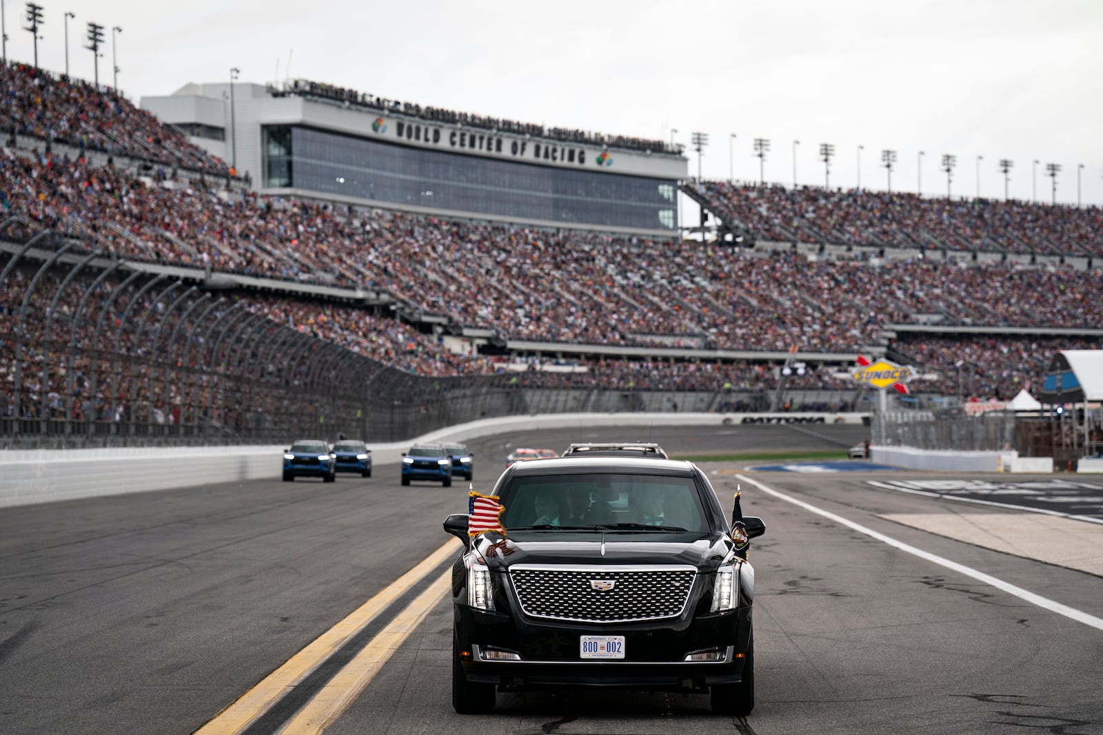 President Donald Trump rides in the presidential limousine known as "The Beast" as he takes a pace lap ahead of the start of the NASCAR Daytona 500 auto race at Daytona International Speedway, Sunday, Feb. 16, 2025, in Daytona Beach, Fla. (Pool via AP)