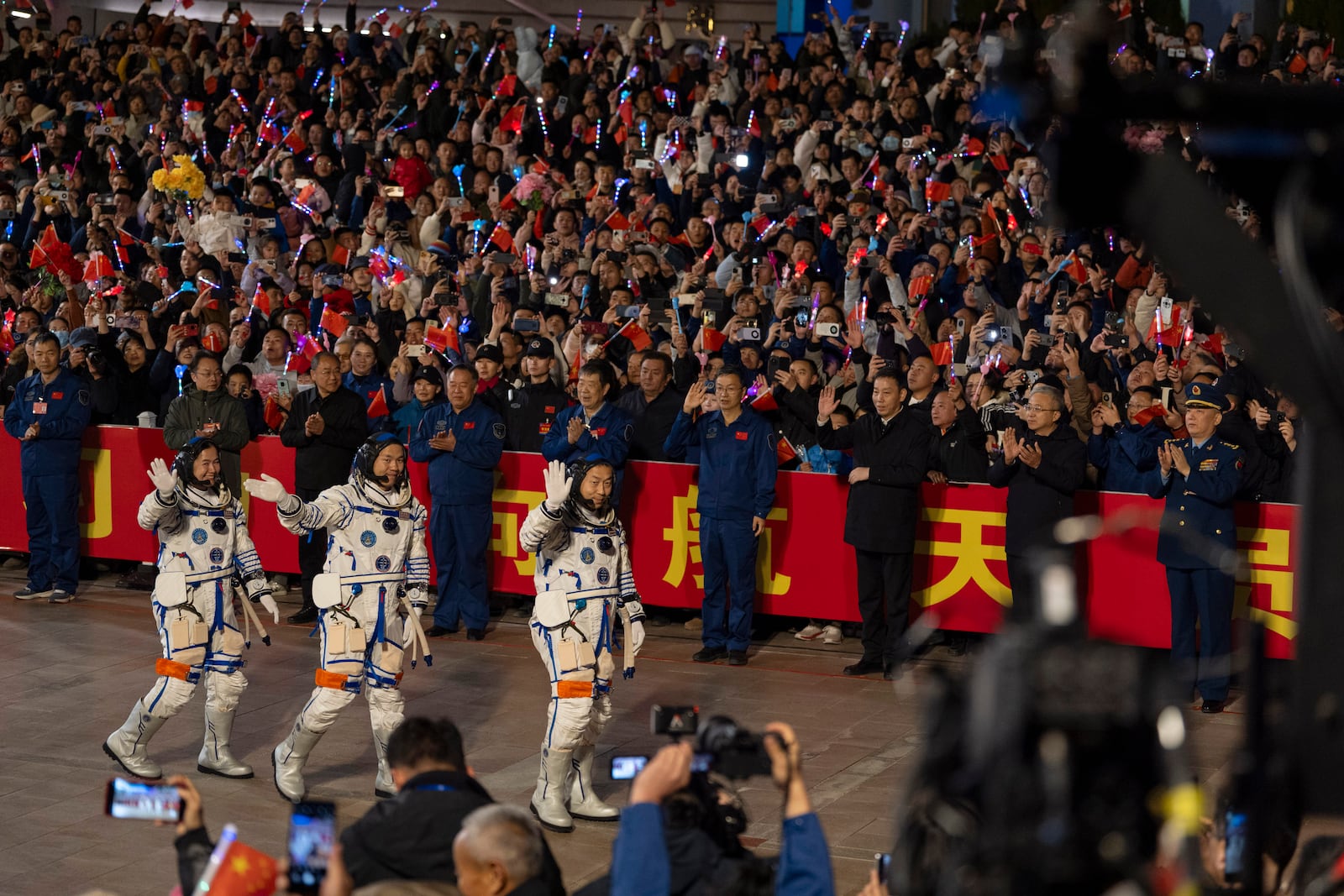 Chinese astronauts Wang Haoze, from left, Song Lingdong and Cai Xuzhe wave during the see-off ceremony for the Shenzhou-19 mission at the Jiuquan Satellite Launch Center in northwestern China, in the early hours of Wednesday, Oct. 30, 2024. (AP Photo/Ng Han Guan)