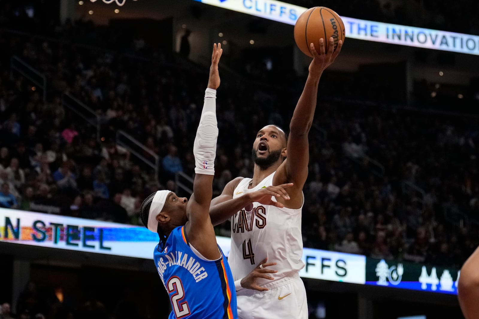 Cleveland Cavaliers forward Evan Mobley (4) shoots as Oklahoma City Thunder guard Shai Gilgeous-Alexander (2) defends in the first half of an NBA basketball game, Wednesday, Jan. 8, 2025, in Cleveland. (AP Photo/Sue Ogrocki)