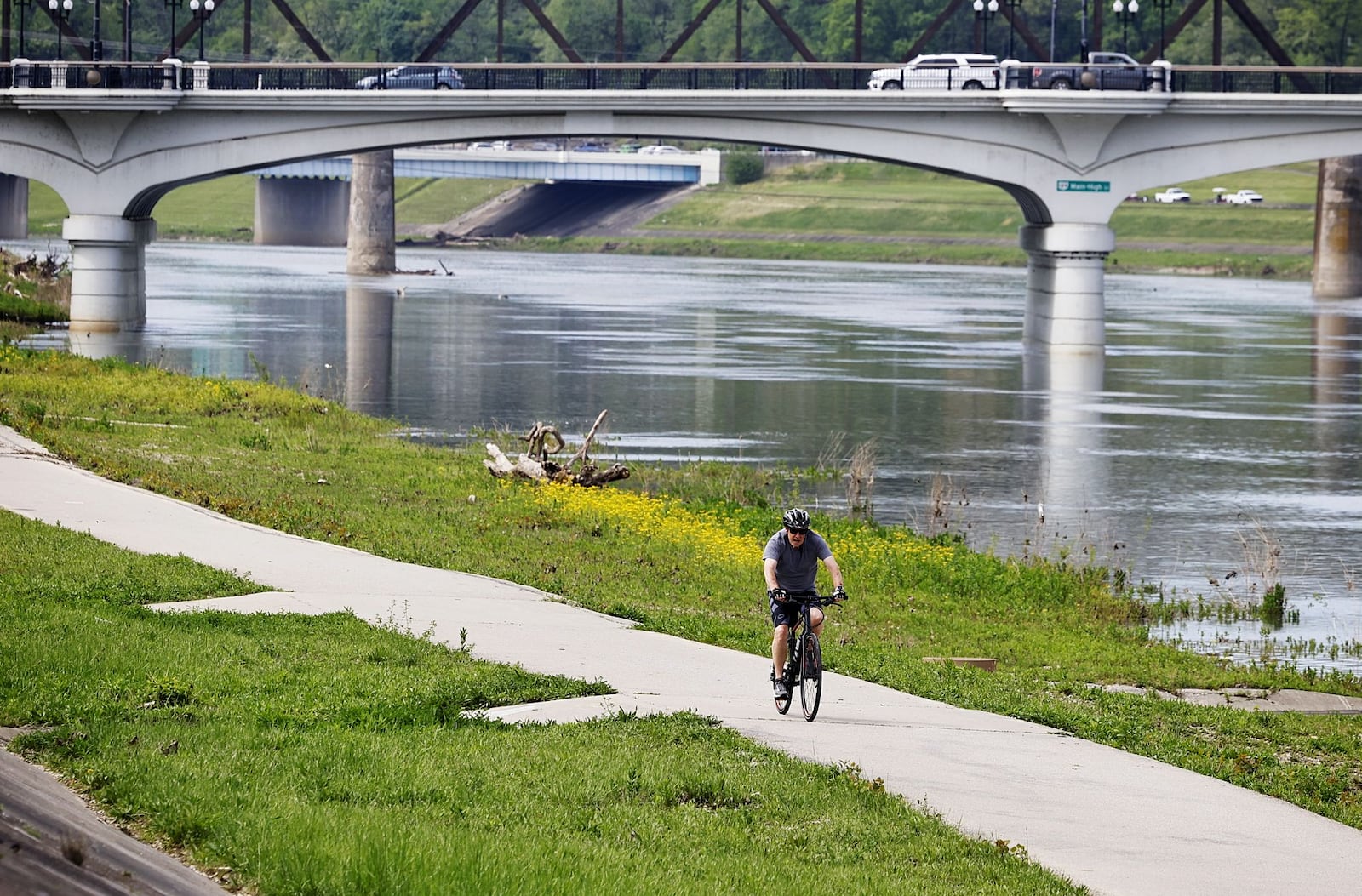 A cyclist rides alimg the Great Miami Ri er in Hamilton. The Hamilton Community Foundation advocated 25 years ago for the extension of the Great Miami River Trail, led by former board chair Dave Belew. This year, the trail in Hamilton is being renamed to honor his legacy. NICK GRAHAM/STAFF