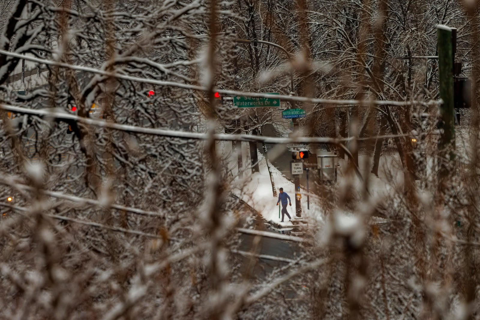 A person walks along Kelly Drive and Water Works Drive after an overnight snow fall in Philadelphia, Wednesday, Feb. 12, 2025. (Alejandro A. Alvarez/The Philadelphia Inquirer via AP)