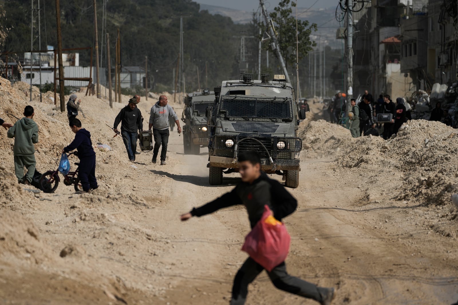 Residents of the West Bank urban refugee camp of Nur Shams evacuate their homes and carry their belongings as the Israeli military continues its operation in the area on Wednesday, March 5, 2025. (AP Photo/Majdi Mohammed)