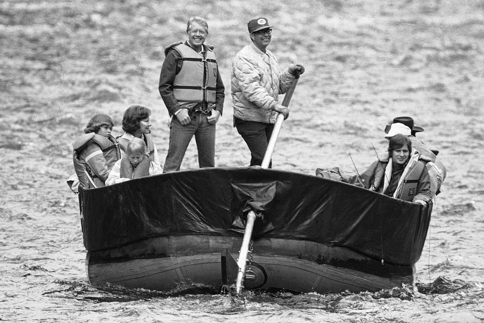 FILE - Guide Norm Guth steers a 20-foot diameter rubber raft carrying President Jimmy Carter and the president's family down the rushing water of Middle Fork of Idaho's Salmon River, Aug. 22, 1978. Carter and his family spent three days on the Idaho wilderness stream. (AP Photo/Harry Cabluck, File)