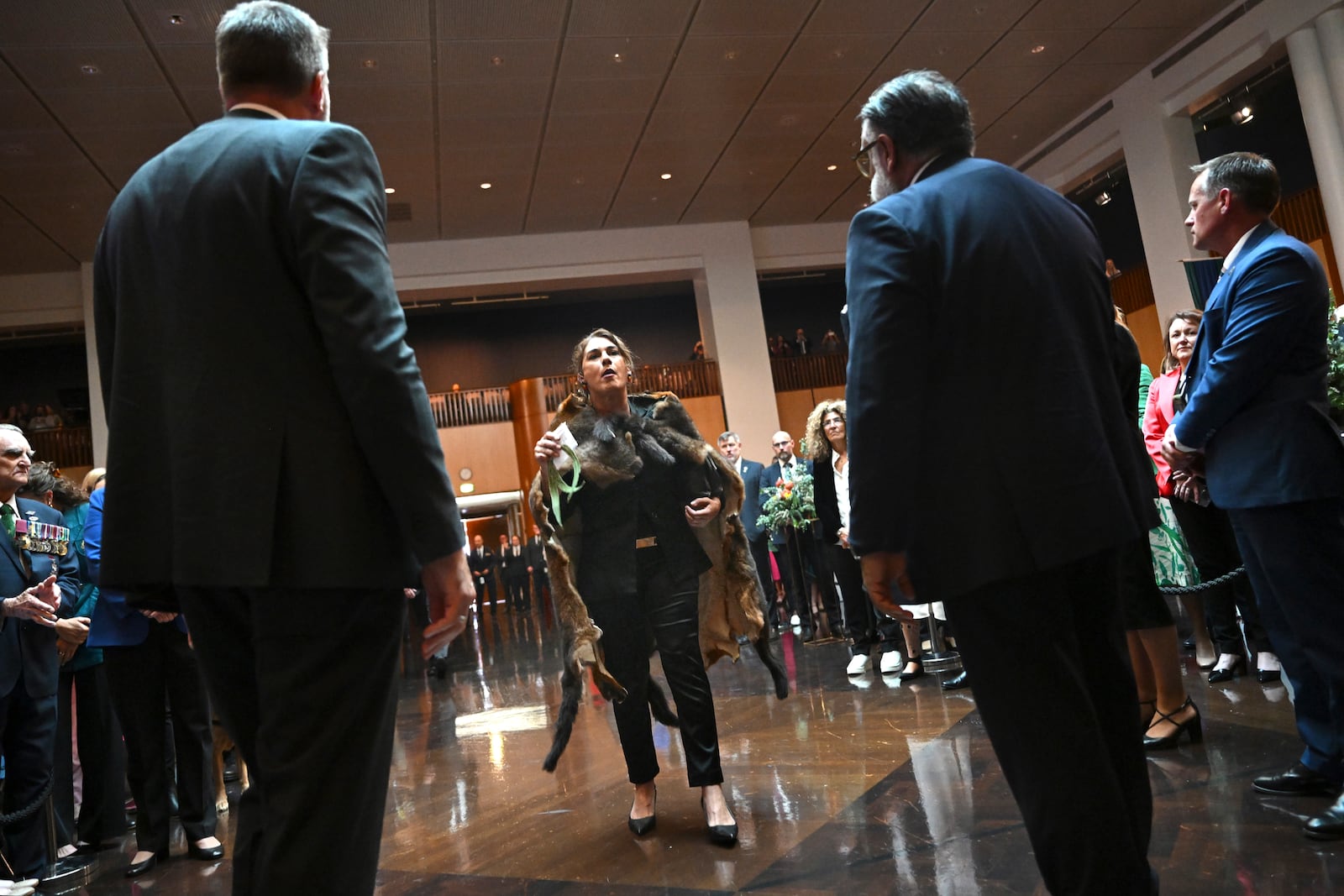 Australian Senator Lidia Thorpe, center, disrupts proceedings as Britain's King Charles III and Queen Camilla attend a Parliamentary reception hosted by Australian Prime Minister Anthony Albanese and partner Jodie Jaydon at Parliament House in Canberra, Australia, Monday, Oct. 21, 2024. (Lukas Coch/Pool Photo via AP)