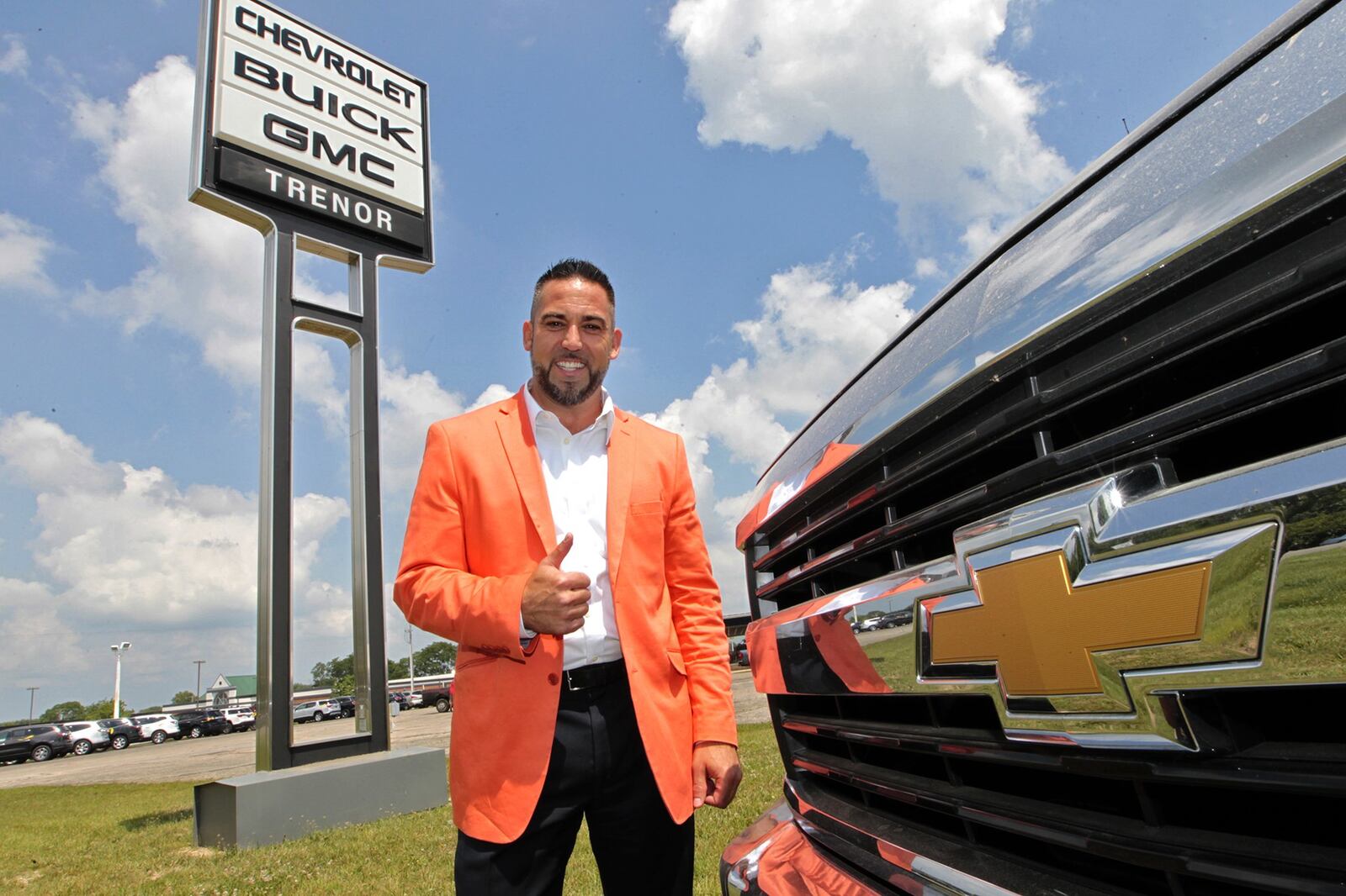 Steve VanGorder, of SVG Motors, poses under the Trenor Chevy, Buick and GMC sign in Urbana Wednesday. SVG Motors recently purchased Trenor, which has been family-run for decades. Bill Lackey/Staff