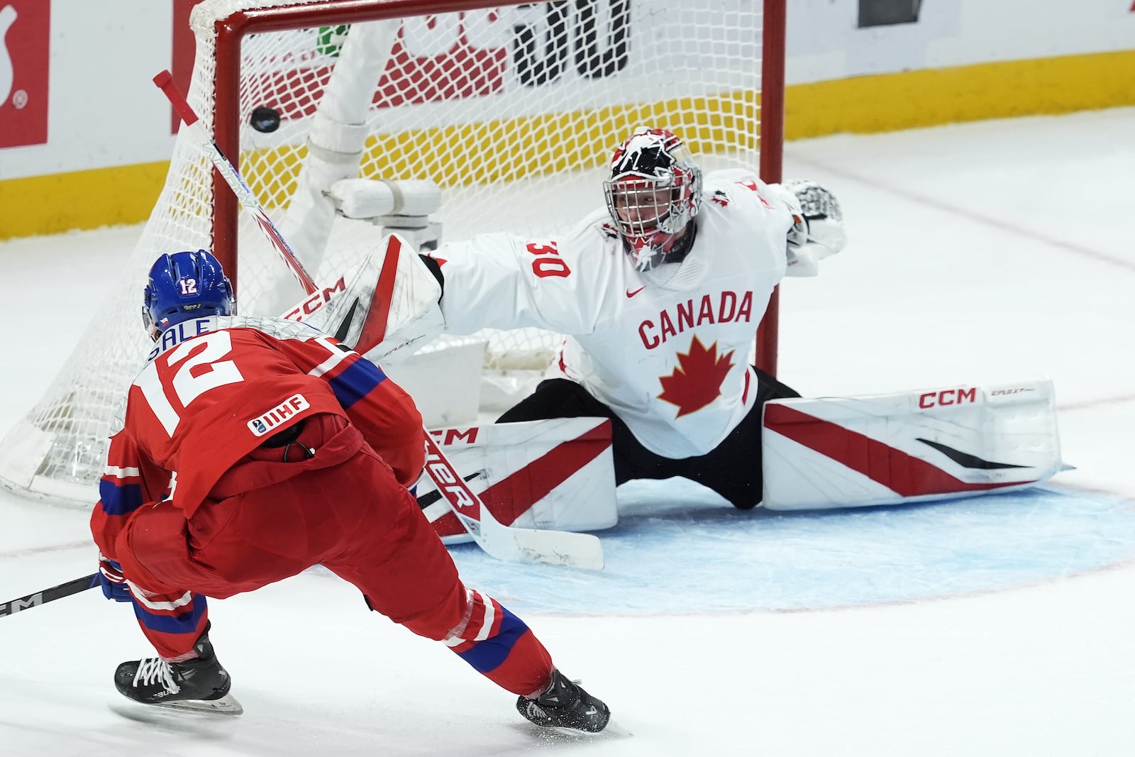 Czech Republic forward Eduard Sale (12) scores on Canada goalkeeper Carter George (30) during the first period of a quarterfinal match at the world junior hockey championship in Ottawa, Ontario, Thursday, Jan. 2, 2025. (Adrian Wyld/The Canadian Press via AP)