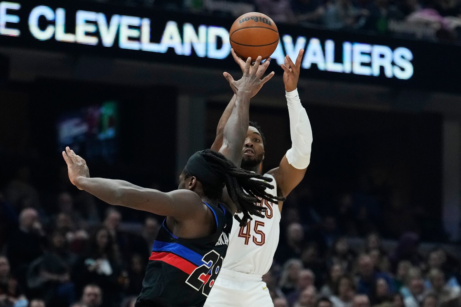 Cleveland Cavaliers guard Donovan Mitchell (45) shoots over Detroit Pistons center Isaiah Stewart (28) in the first half of an NBA basketball game, Monday, Jan. 27, 2025, in Cleveland. (AP Photo/Sue Ogrocki)