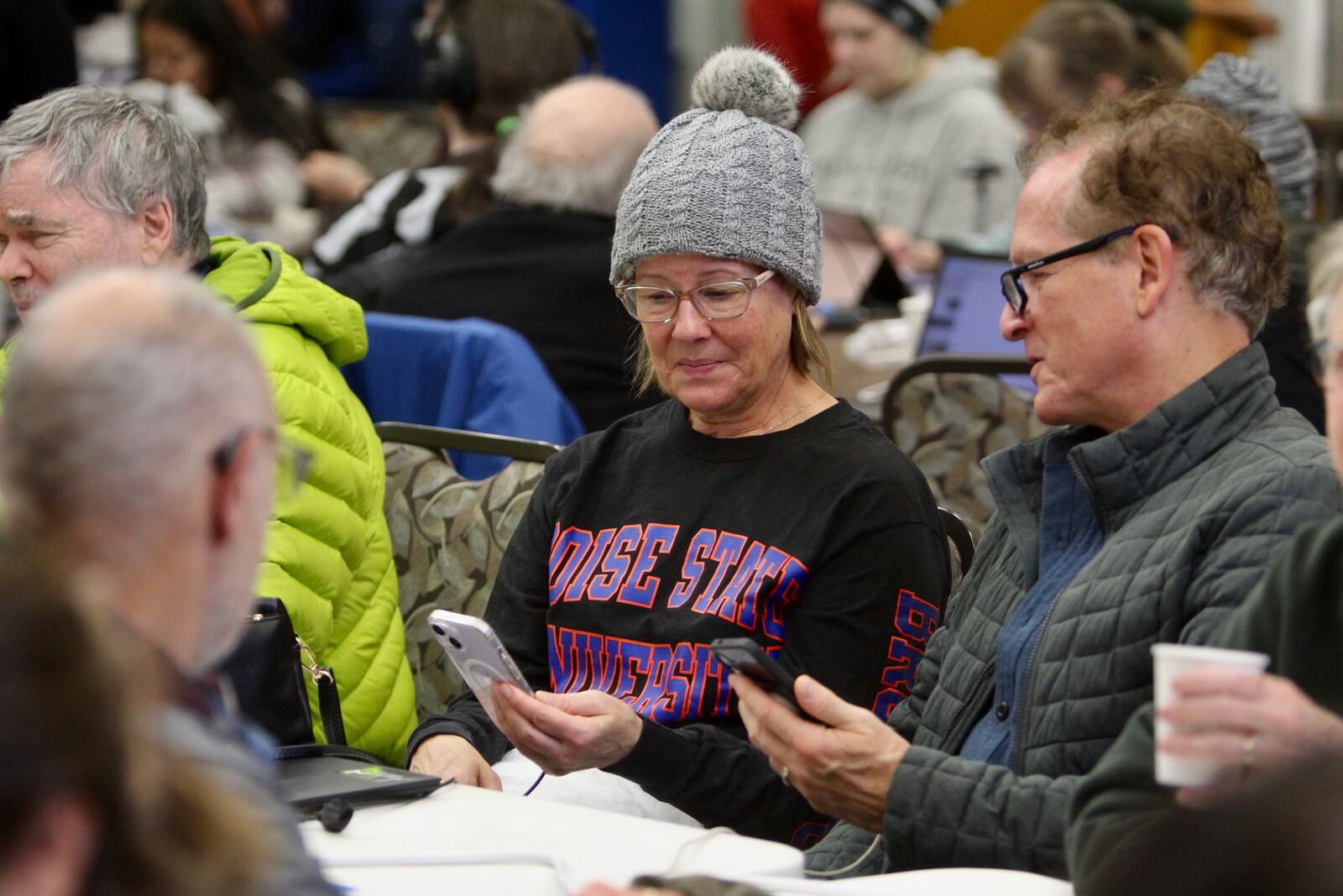 Linda Ryall and Todd Nielsen look at each other's phones at a charging station located in the Issaquah Senior Center in Issaquah, Wash., Friday, Nov. 22, 2024. (AP Photo/Manuel Valdes)