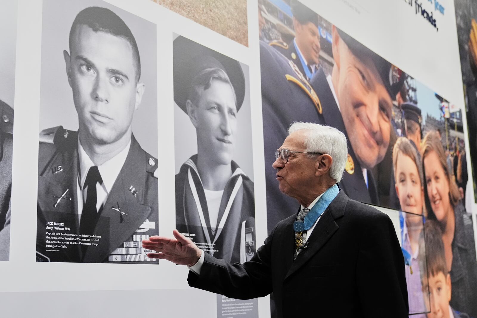 Jack Jacobs, a retired U.S. Army colonel who was awarded the Medal of Honor for his actions during the Vietnam War, points to his military head shot, left, as he tells a story from his early career during an interview at the National Medal of Honor Museum in Arlington, Texas, Thursday, March 13, 2025. (AP Photo/Tony Gutierrez)