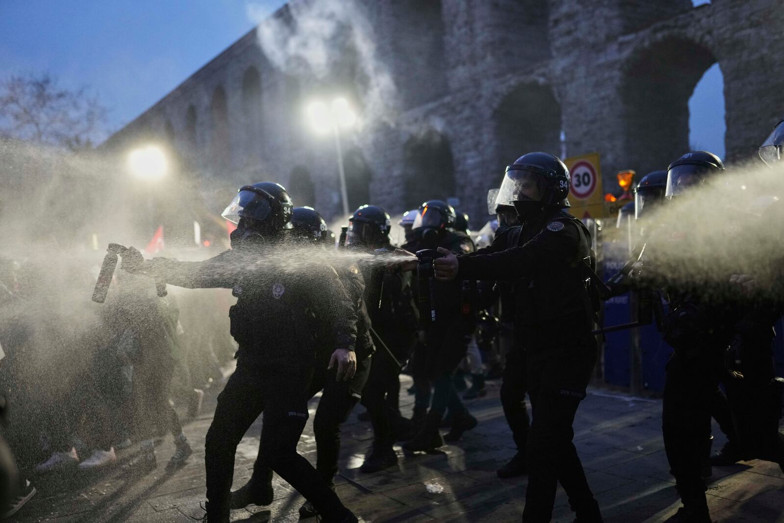 Riot police officers use pepper spray to clear protesters during a protest after Istanbul's Mayor Ekrem Imamoglu was arrested and sent to prison, in Istanbul, Turkey, Sunday, March 23, 2025. (AP Photo/Francisco Seco)