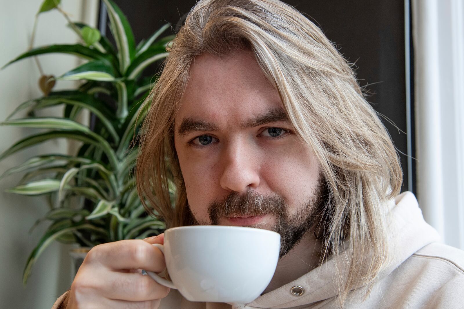 YouTuber Sean McLoughlin, better known as 'Jacksepticeye,' drinks a coffee at his favorite coffee shop in Brighton, Thursday, November 21, 2024. (AP Photo/Thomas Krych)