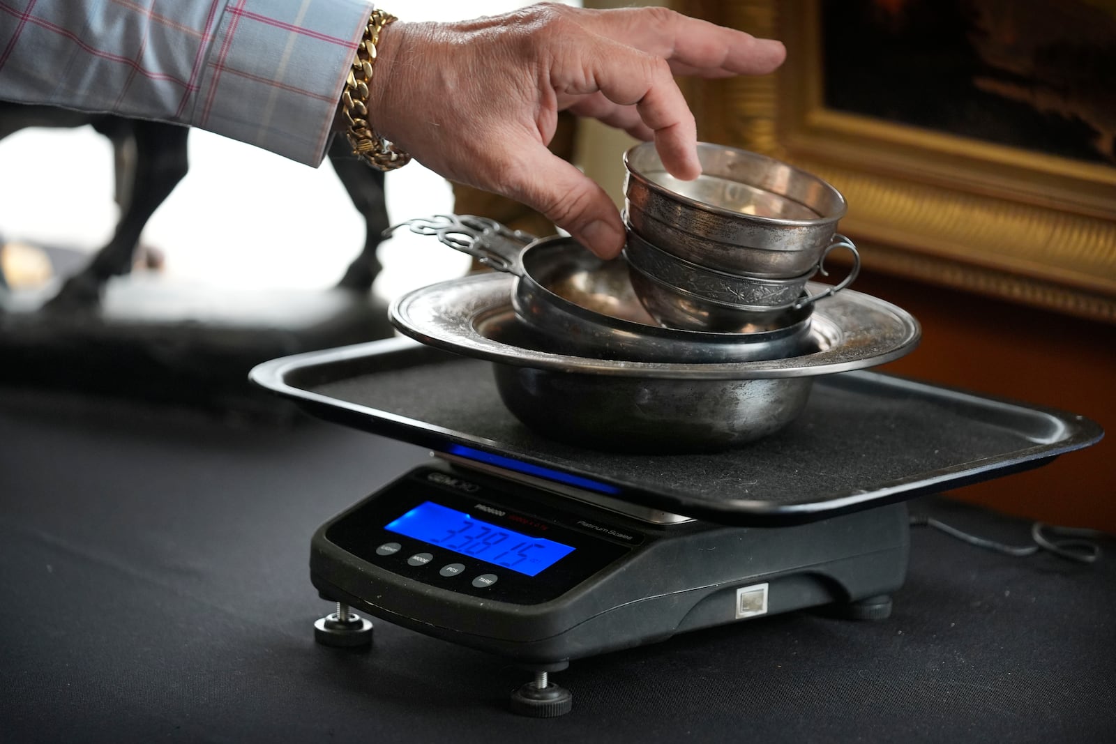 Silverware is weighed during an appraisal at Thomaston Place Auction Galleries, Tuesday, Nov. 19, 2024, in Thomaston, Maine. (AP Photo/Robert F. Bukaty)