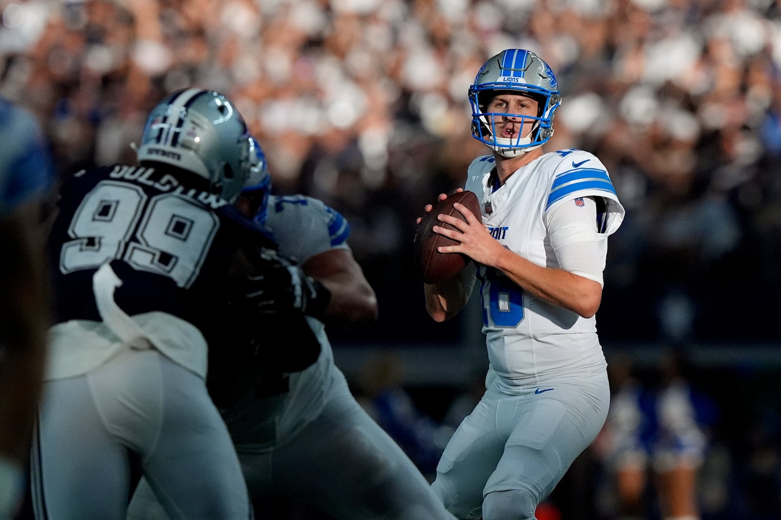 Detroit Lions quarterback Jared Goff drops back to pass under pressure from Dallas Cowboys defensive end Chauncey Golston (99) in the second half of an NFL football game in Arlington, Texas, Sunday, Oct. 13, 2024. (AP Photo/LM Otero)