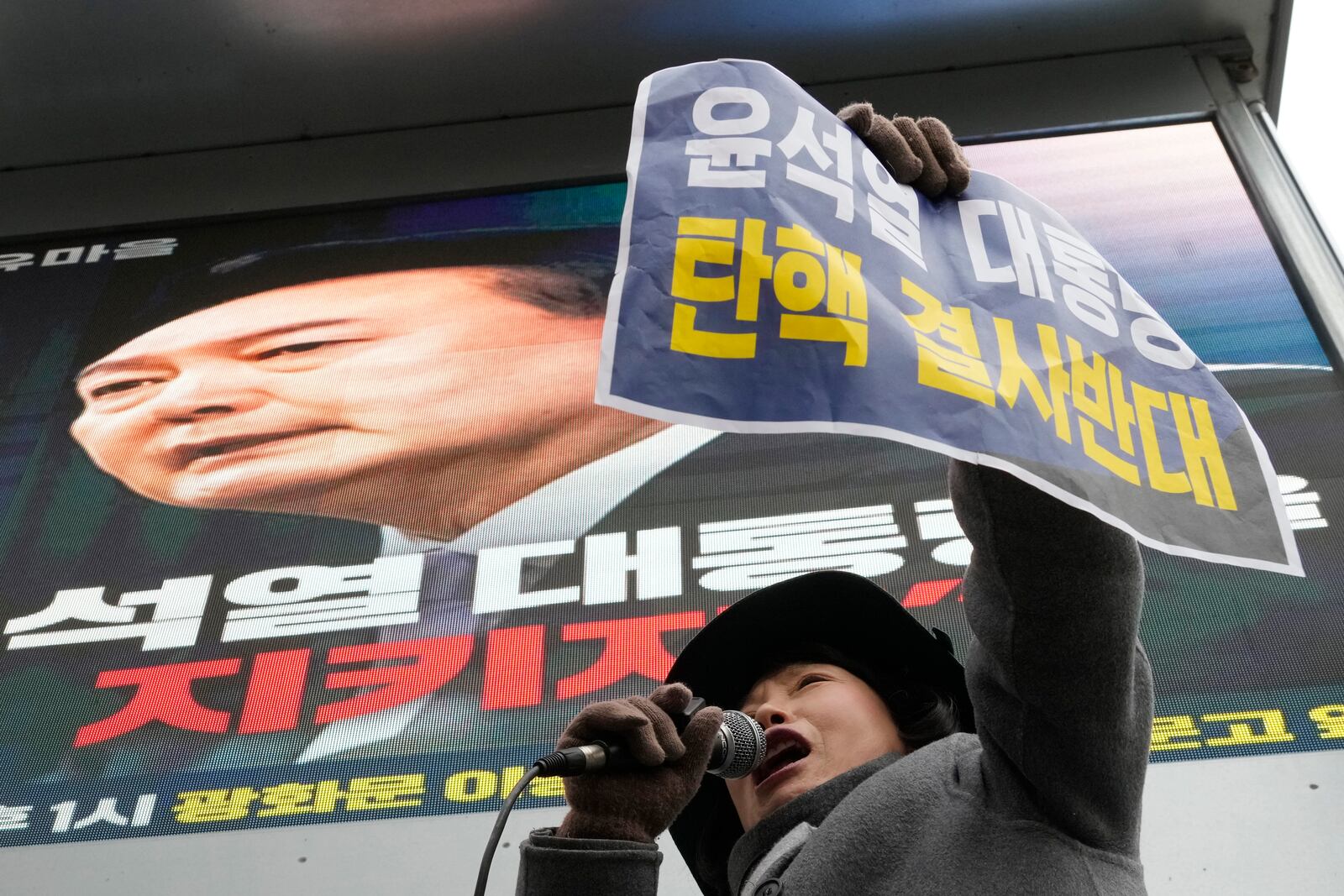 A supporter for impeached South Korean President Yoon Suk Yeol shouts slogans during a rally against his impeachment near the Constitutional Court in Seoul, South Korea, Friday, Dec. 20, 2024. The signs read "Oppose the impeachment of President Yoon Suk Yeol." (AP Photo/Ahn Young-joon)