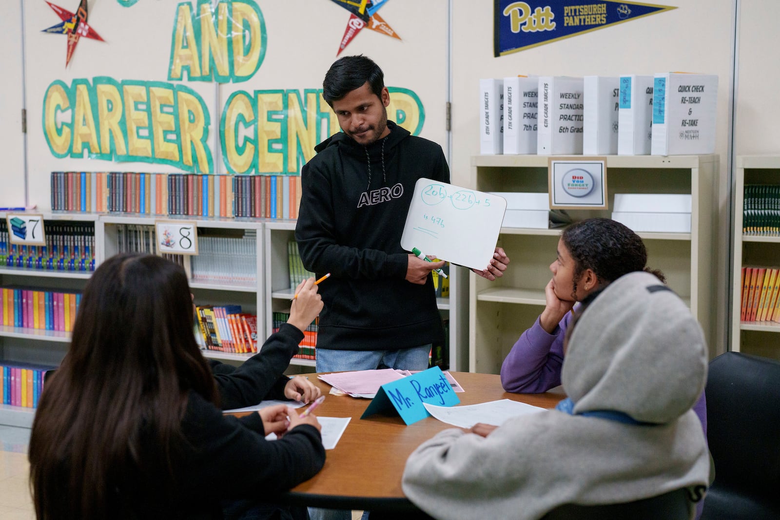 A tutor helps students at Benjamin O. Davis Middle School in Compton, Calif., Thursday, Feb. 6, 2025. (AP Photo/Eric Thayer)