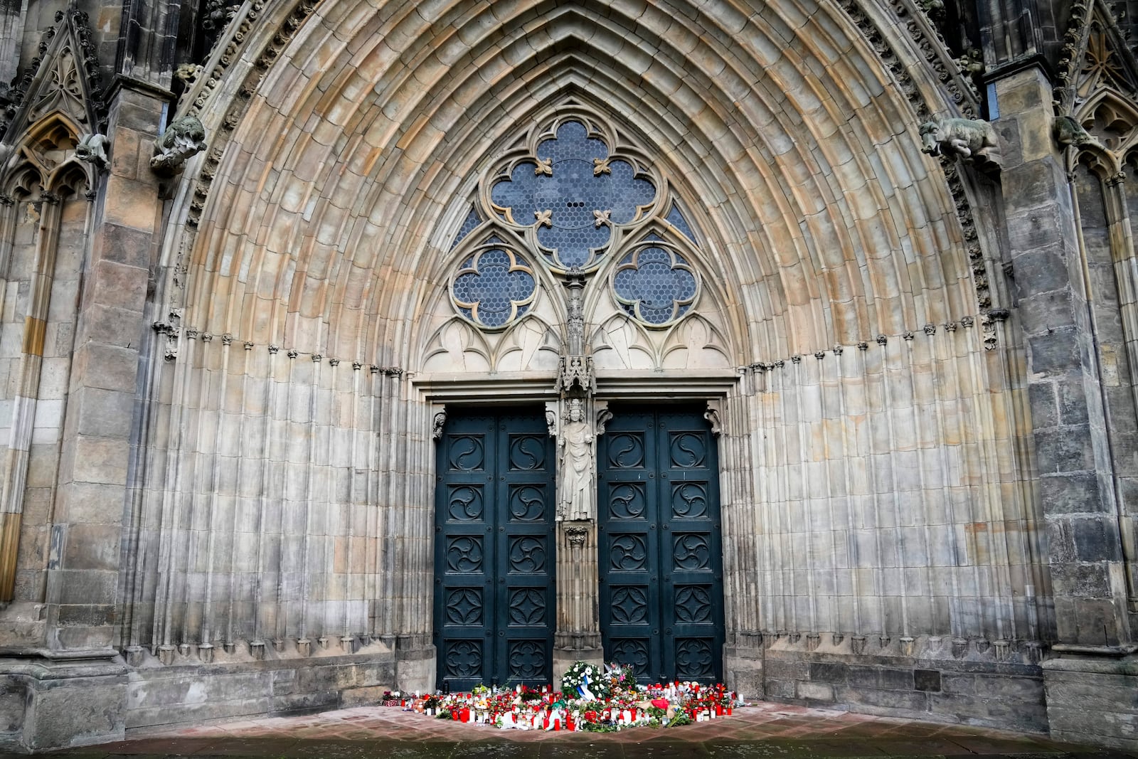 Flowers and candles laid down in front of the Magdeburg Cathedra, after a car drove into a crowd of a Christmas Mark on Friday evening, in Magdeburg, Germany, Sunday, Dec. 22, 2024. (AP Photo/Ebrahim Noroozi)