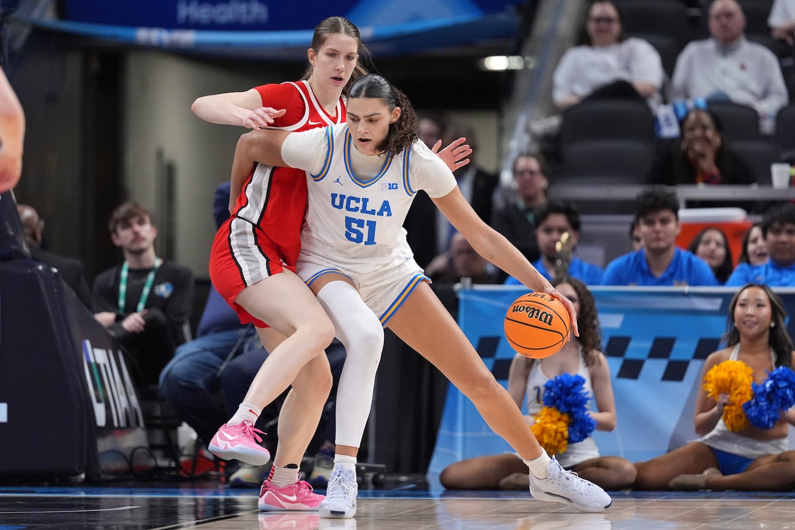 UCLA center Lauren Betts (51) drives on Ohio State center Elsa Lemmila (12) during the second half of an NCAA college basketball game in the semifinals of the Big Ten Conference tournament in Indianapolis, Saturday, March 8, 2025. (AP Photo/Michael Conroy)