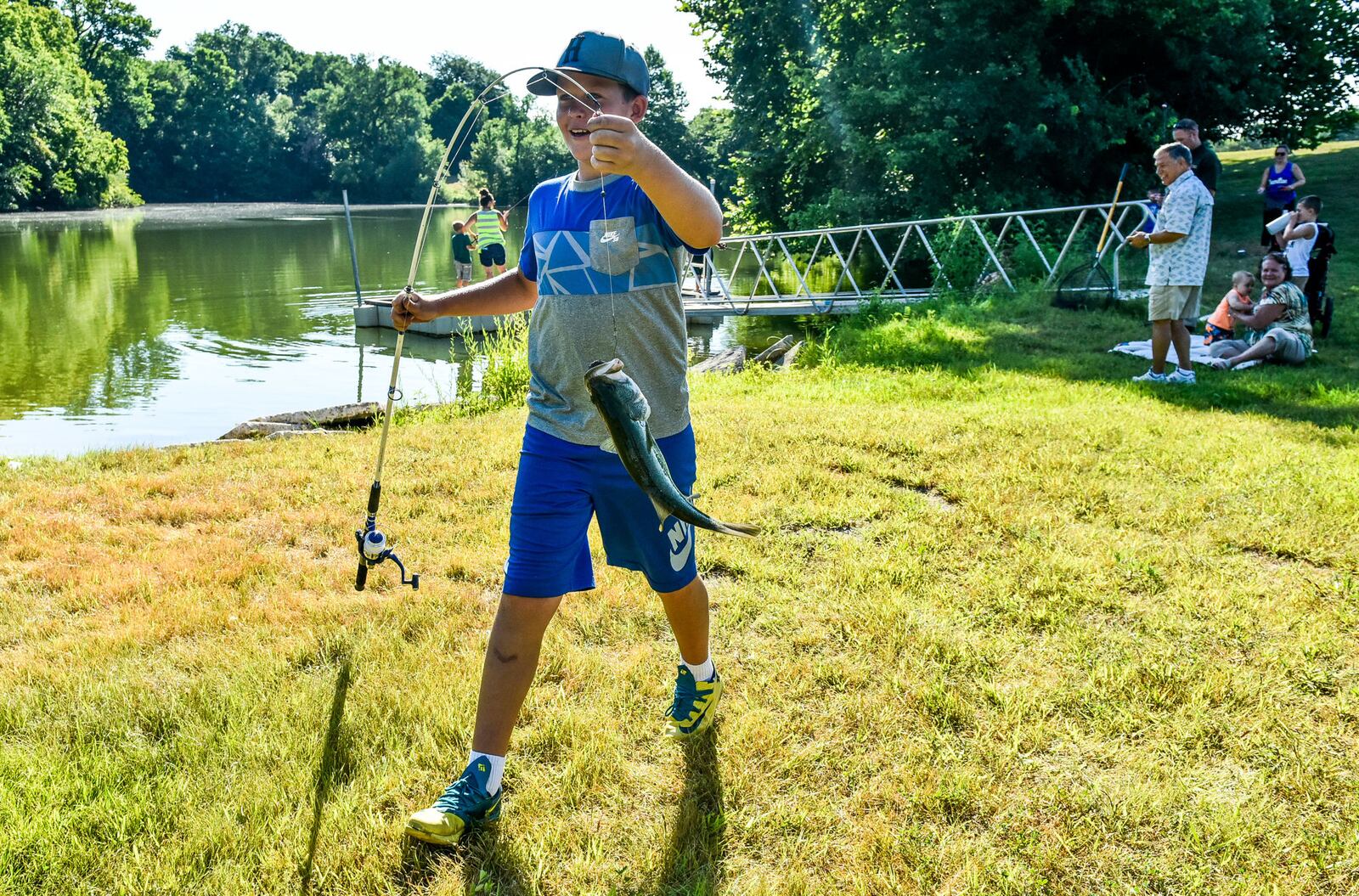 Jacob Baker rushes to get his fish weighed during the Fish with a Cop event Tuesday, July 17, at Fairfield Optimist Club pond. 