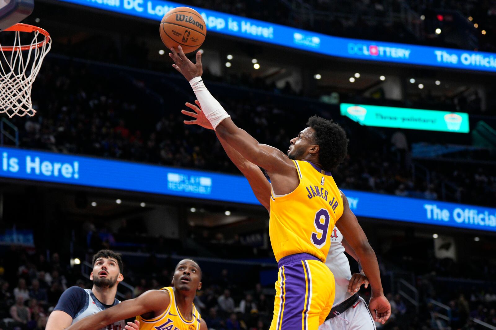 Los Angeles Lakers guard Bronny James (9) goes up for a shot against Washington Wizards guard Jared Butler (4) during the second half of an NBA basketball game Thursday, Jan. 30, 2025, in Washington. (AP Photo/Jess Rapfogel)