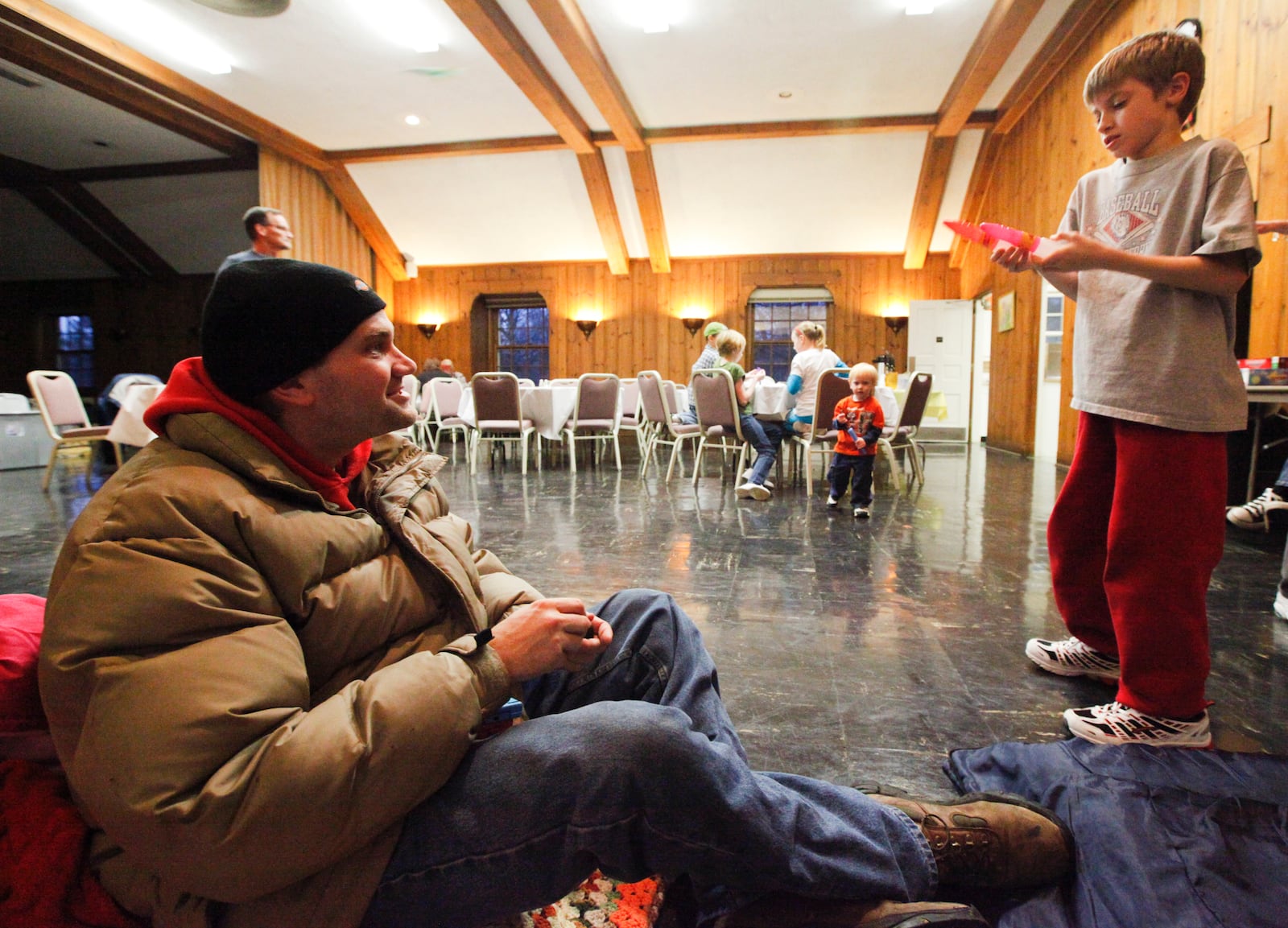 Timothy Conklin, a homeless Marine veteran, sits on a thin mat that will become one of the family member's bed as he talks with his son Cody inside the SHALOM (Serving Homeless with Alternate Lodging Of Middletown) shelter at the First Presbyterian Church in Middletown. The shelter won't open this season due to coronavirus concerns. FILE PHOTO