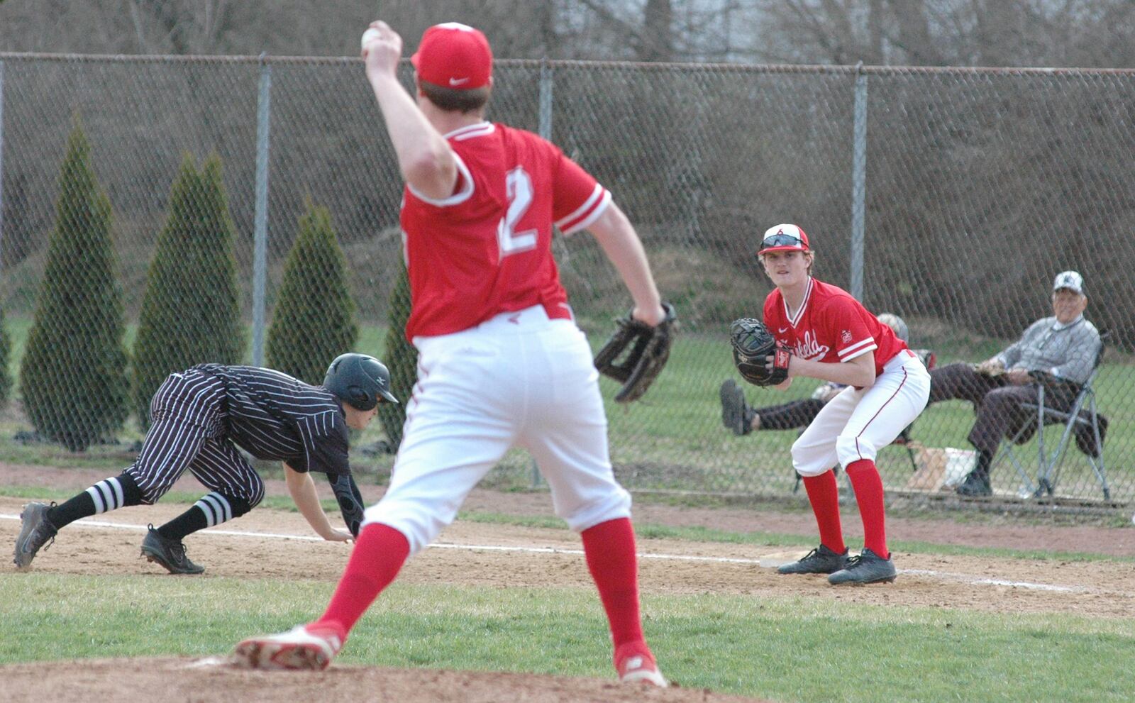 Fairfield pitcher Aidan Post throws to first baseman Jacob Sheriff in an effort to pick off Lakota East’s Grayson Hamilton on Wednesday at Joe Nuxhall Field in Fairfield. East won the Greater Miami Conference baseball game 2-1. RICK CASSANO/STAFF