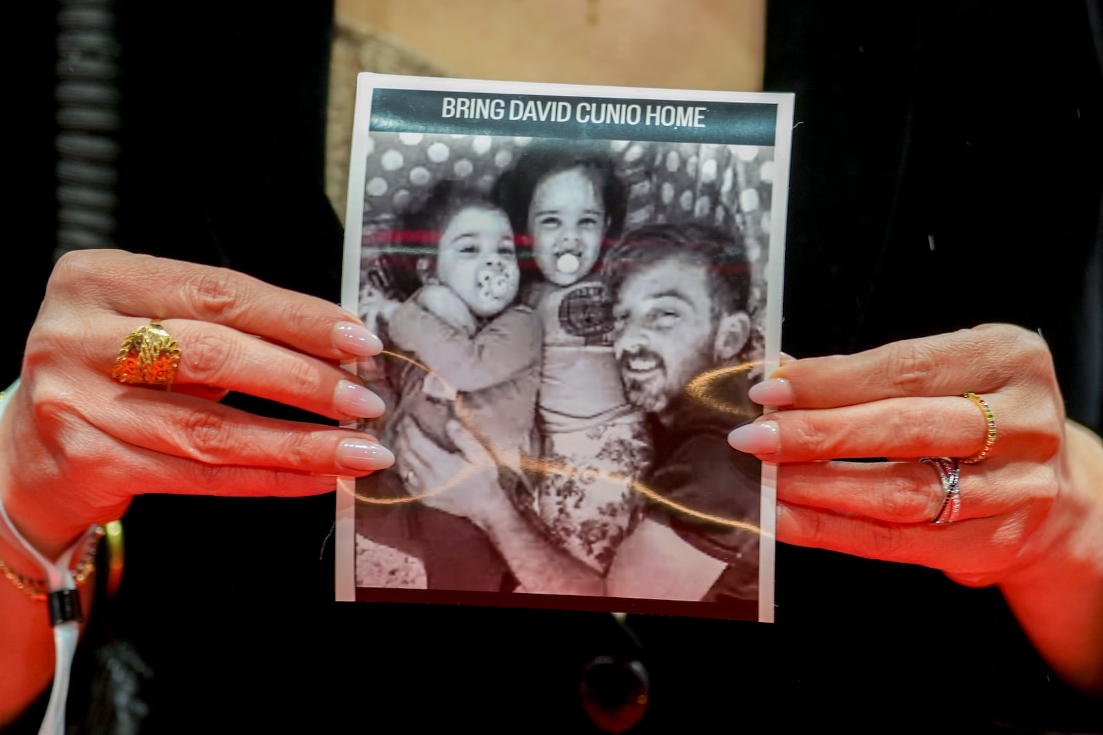 A German actress holds a photo of Israeli hostage David Cunio upon arrival at the opening of the International Film Festival, Berlinale, in Berlin, Thursday, Feb. 13, 2025. (AP Photo/Markus Schreiber)