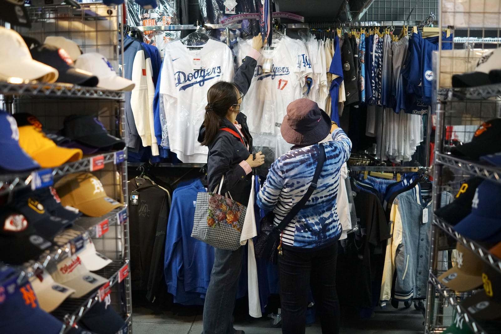 Customers shop around for goods related to Shohei Ohtani of the Los Angeles Dodgers at a sporting goods store, "SELECTION," in Shinjuku district Wednesday, Oct. 23, 2024 in Tokyo. (AP Photo/Eugene Hoshiko)