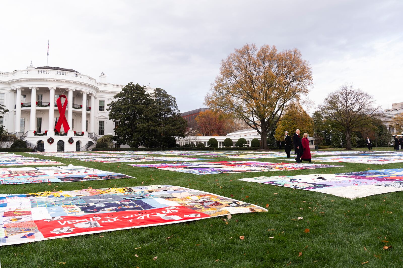 President Joe Biden and first lady Jill Biden walk between AIDS Memorial Quilts spread over the South Lawn of the White House during a ceremony to commemorate World AIDS Day with survivors, their families and advocates, Sunday, Dec. 1, 2024, in Washington. (AP Photo/Manuel Balce Ceneta)