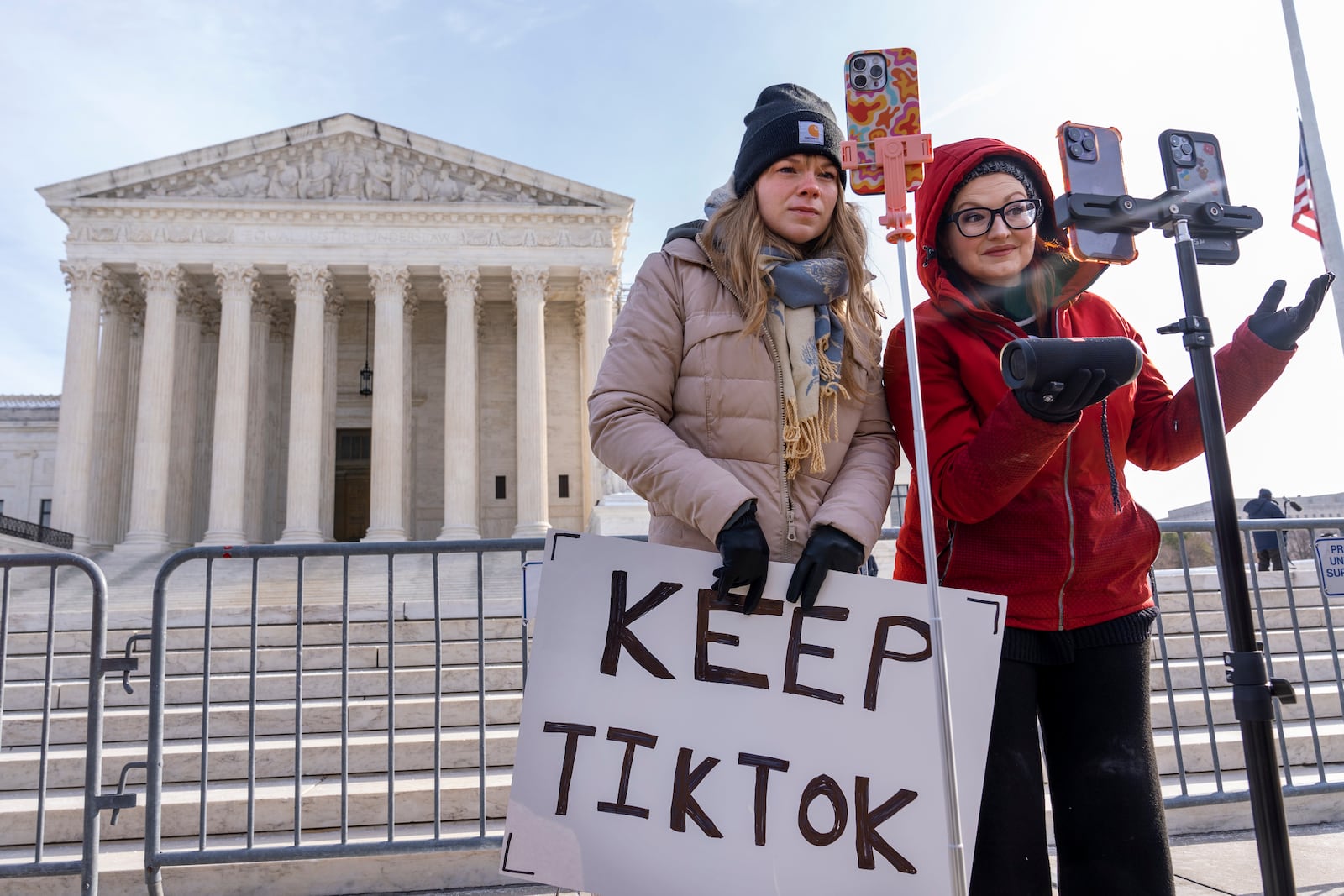 Sarah Baus, left, of Charleston, S.C., and Tiffany Cianci, who says she is a "long-form educational content creator," livestream to TikTok outside the Supreme Court, Friday, Jan. 10, 2025, in Washington. (AP Photo/Jacquelyn Martin)