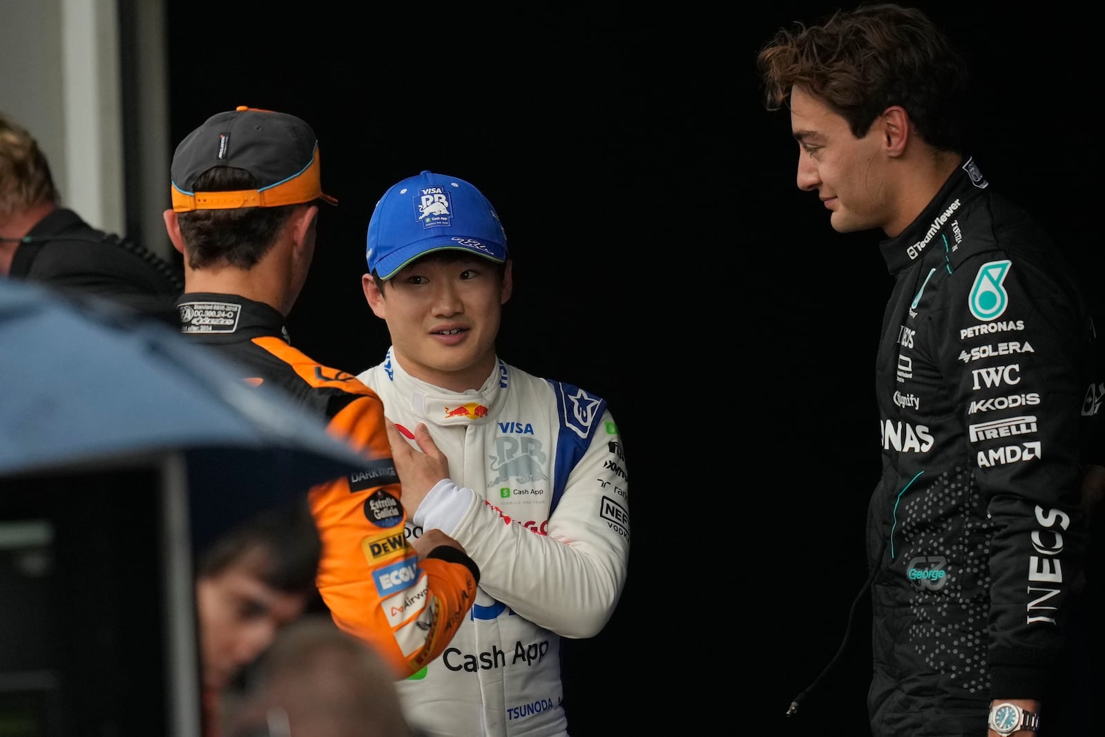 RB driver Yuki Tsunoda of Japan, center, talks with Mercedes driver George Russell of Britain, right, and McLaren driver Lando Norris of Britain, after the qualifying session ahead of the Brazilian Formula One Grand Prix at the Interlagos race track, in Sao Paulo, Brazil, Sunday, Nov. 3, 2024. (AP Photo/Andre Penner)