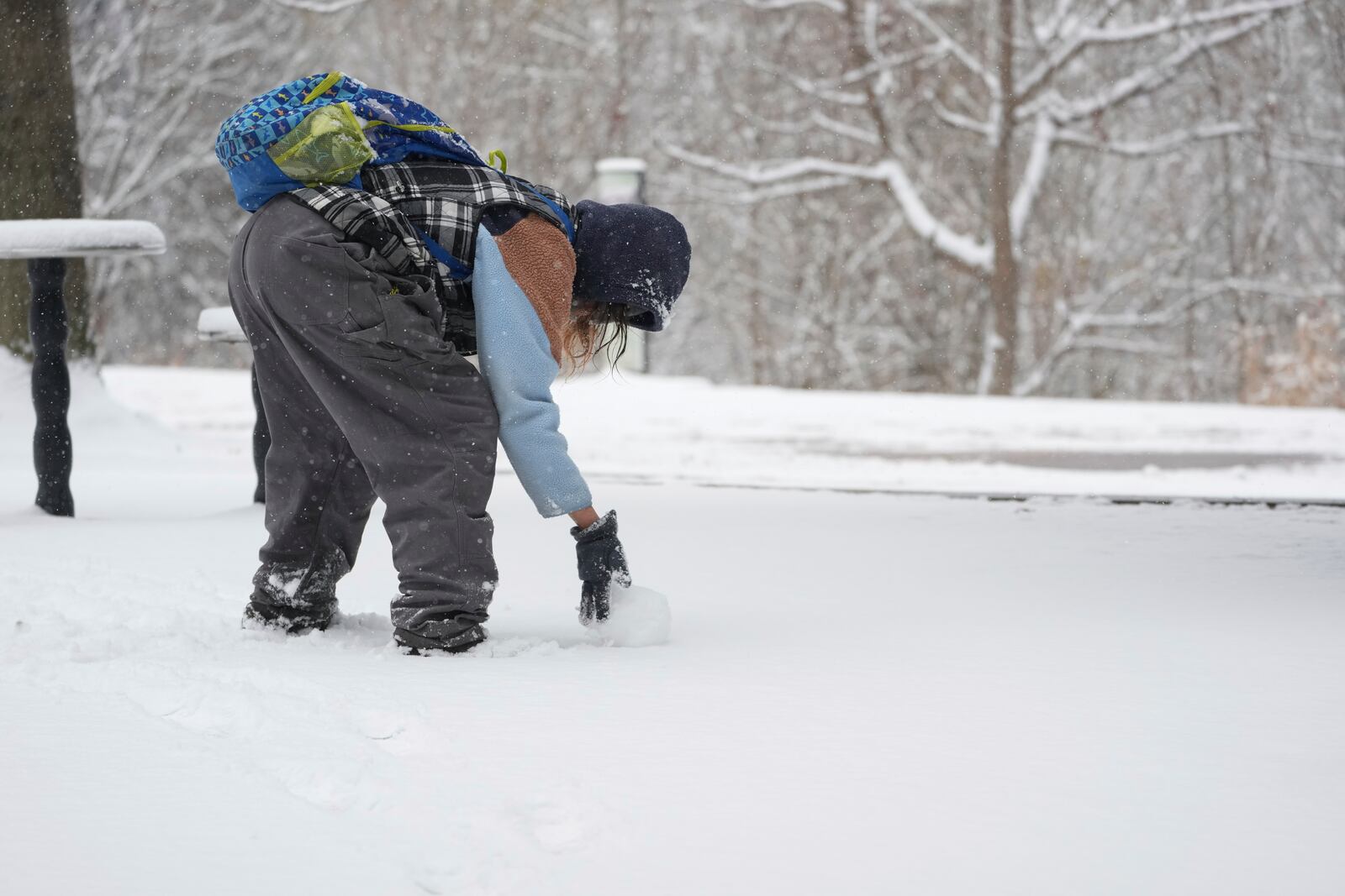 Tiffany Prichard rolls a snow ball to build a snowman Friday, Jan 10, 2025, in Nashville, Tenn. (AP Photo/George Walker IV)