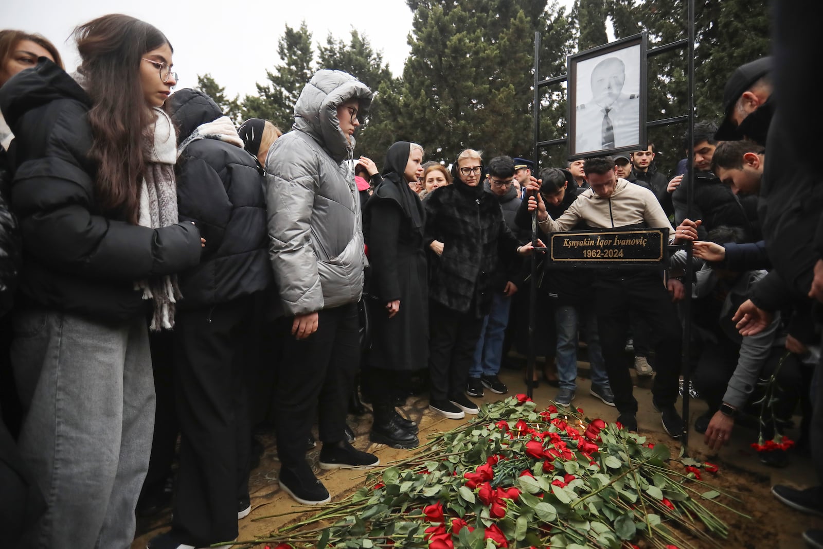 People stand at the grave of pilot in command Igor Kshnyakin during a funeral of the crew members of the Azerbaijan Airlines Embraer 190 killed in a deadly plane crash in Kazakhstan this week, at the II Alley of Honor in Baku, Azerbaijan, Sunday, Dec. 29, 2024. (AP photo)