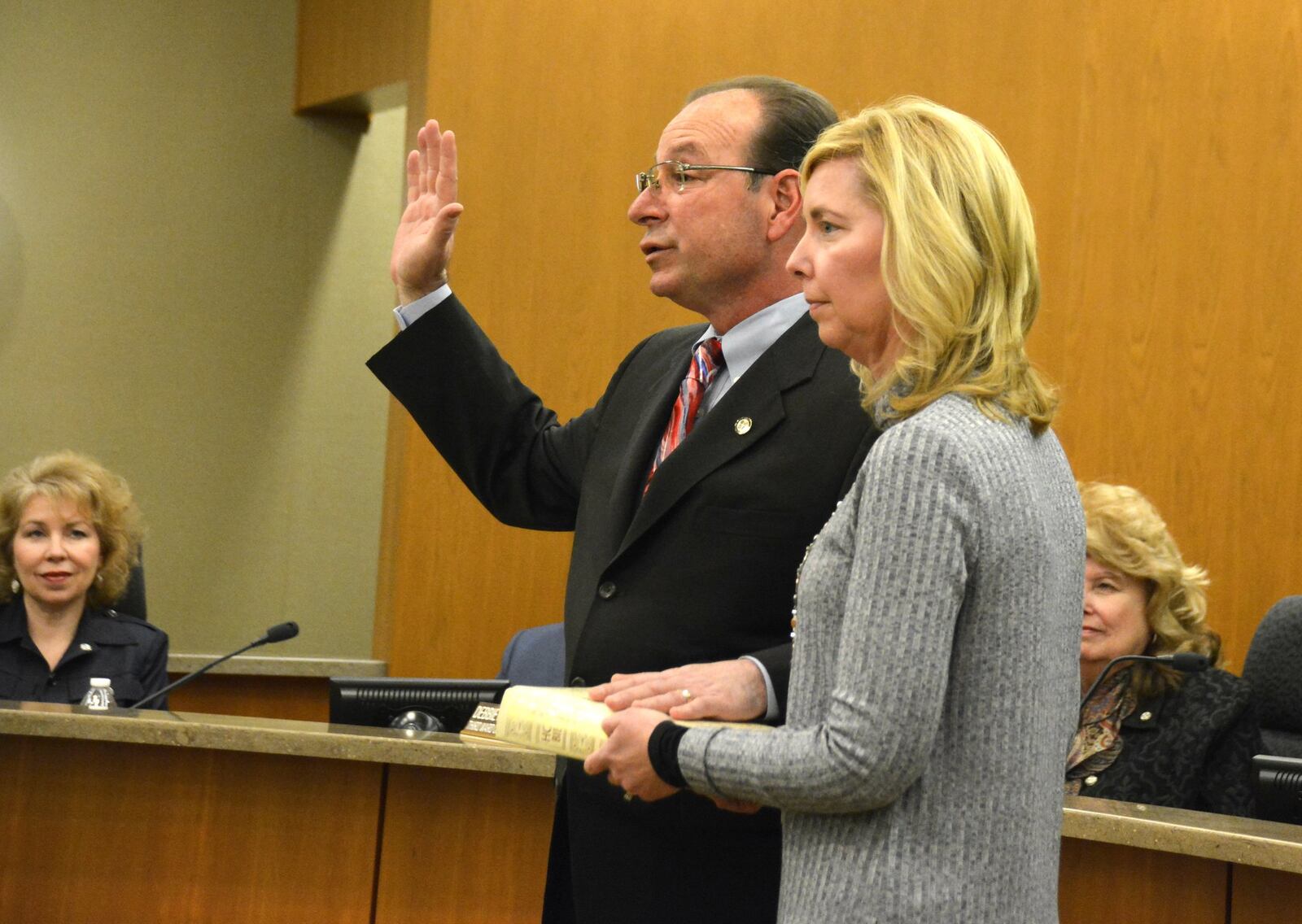 Fairfield Mayor Steve Miller takes the oath of office on Thursday, Dec. 28, 2017, for his second term as the city’s mayor. Miller ran unopposed in the November 2017 general election. His wife, Michelle, holds his family’s bible to take the oath administered by Fairfield Municipal Court Judge Joyce Campbell (not pictured). MICHAEL D. PITMAN.