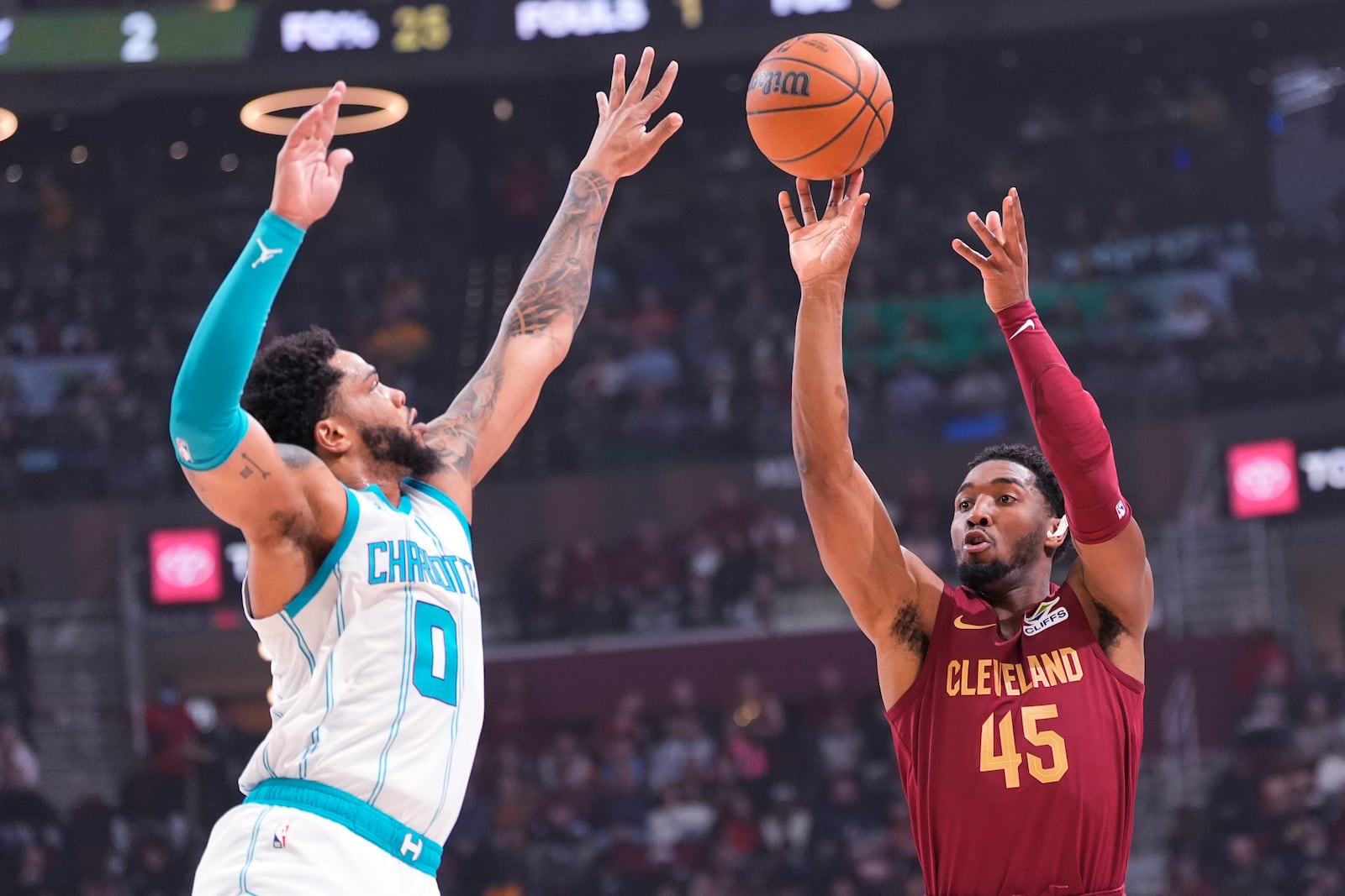 Cleveland Cavaliers guard Donovan Mitchell (45) shoots as Charlotte Hornets forward Miles Bridges (0) defends in the first half of an NBA basketball game, Sunday, Jan. 5, 2025, in Cleveland. (AP Photo/Sue Ogrocki)