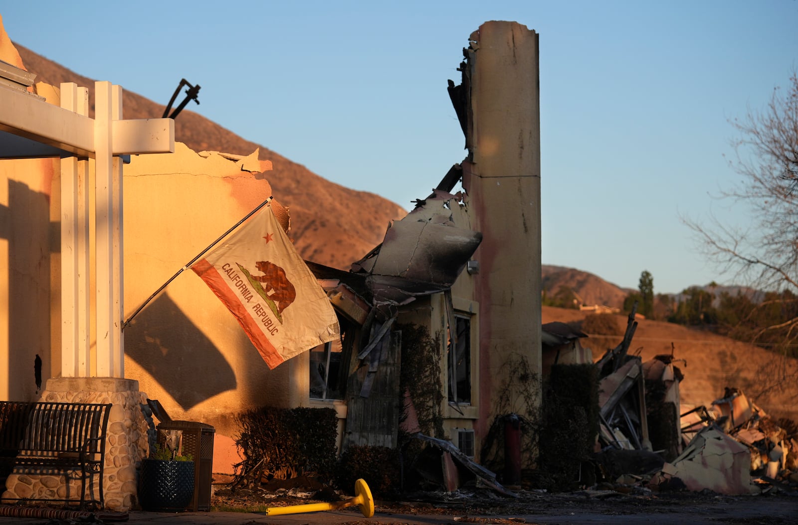 A California state flag hangs outside the charred remains of the Terraces at Park Marino assisted living facility on Monday, Jan. 13, 2025, in Pasadena, Calif. (AP Photo/Chris Pizzello)