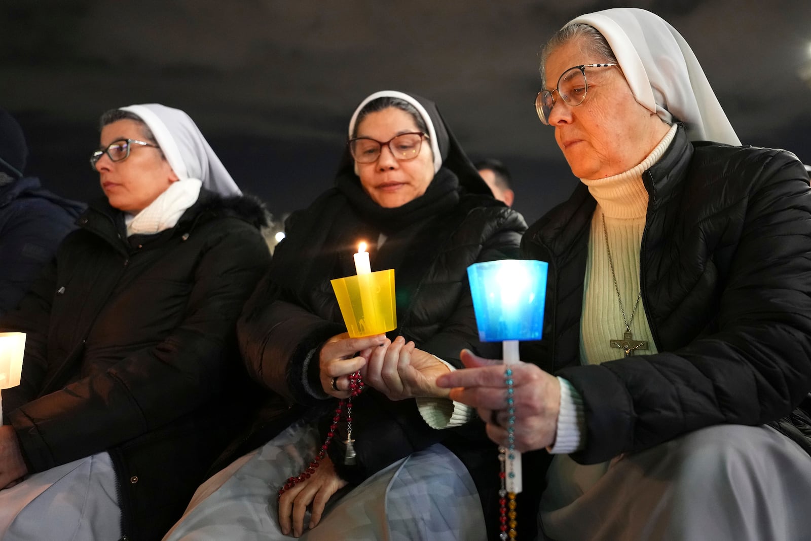 People attend a rosary prayer with Cardinal Victor Manuel Fernandez held for the health of Pope Francis in St Peter's Square at The Vatican, Friday, Feb. 28, 2025. (AP Photo/Kirsty Wigglesworth)