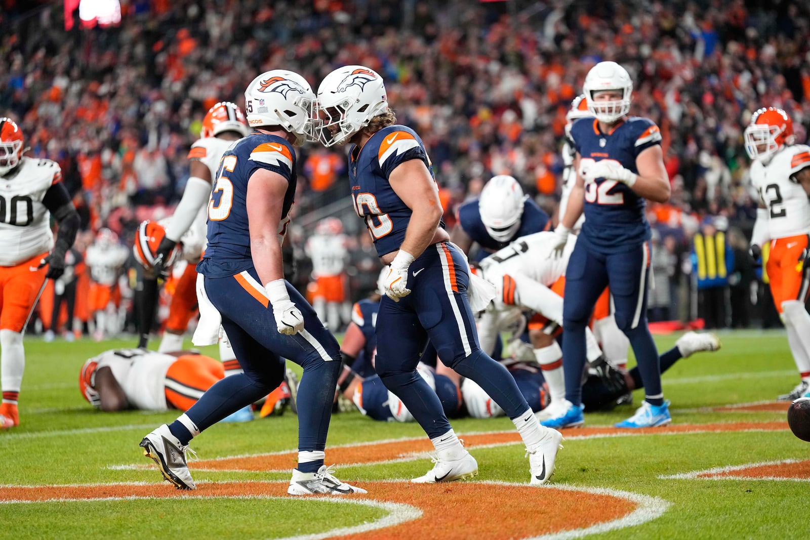 Denver Broncos fullback Michael Burton, right, celebrates his 1-yard rushing touchdown with teammate tight end Nate Adkins during the first half of an NFL football game against the Cleveland Browns, Monday, Dec. 2, 2024, in Denver. (AP Photo/Jack Dempsey)