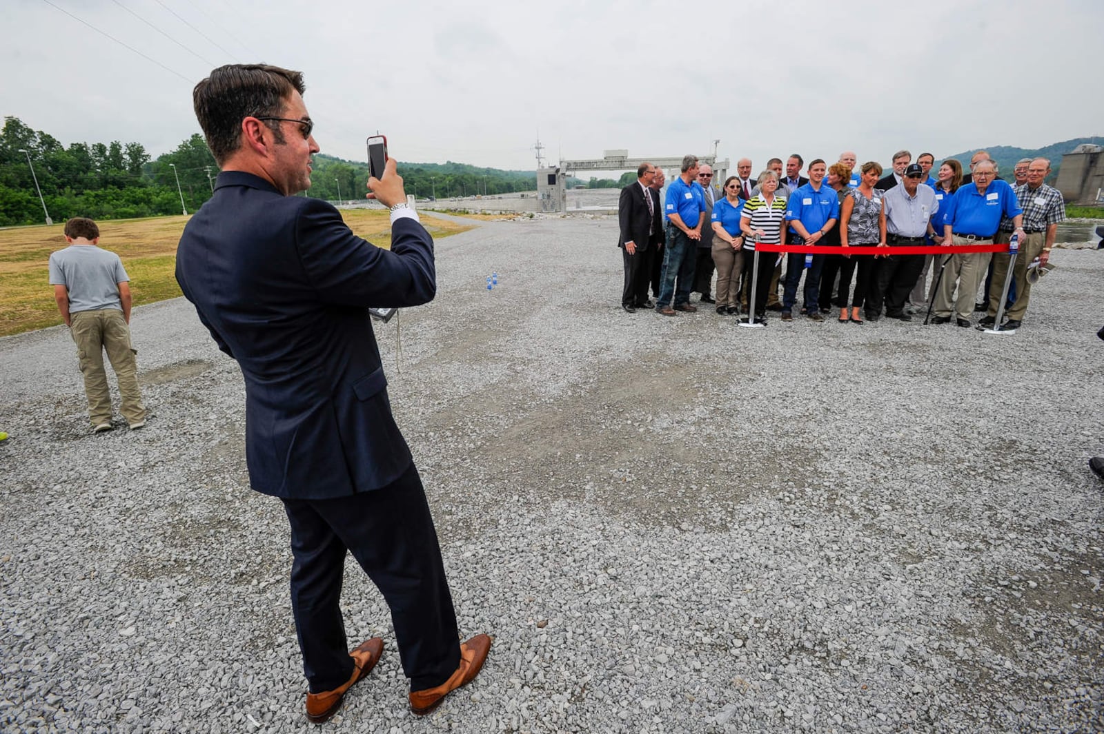 Hamilton city manager Joshua Smith takes a photo other city employees during a ribbon cutting as the city of Hamilton and American Municipal Power, Inc. held a dedication ceremony for the Meldahl hydroelectric plant  in 2016 in Foster, Kentucky. 