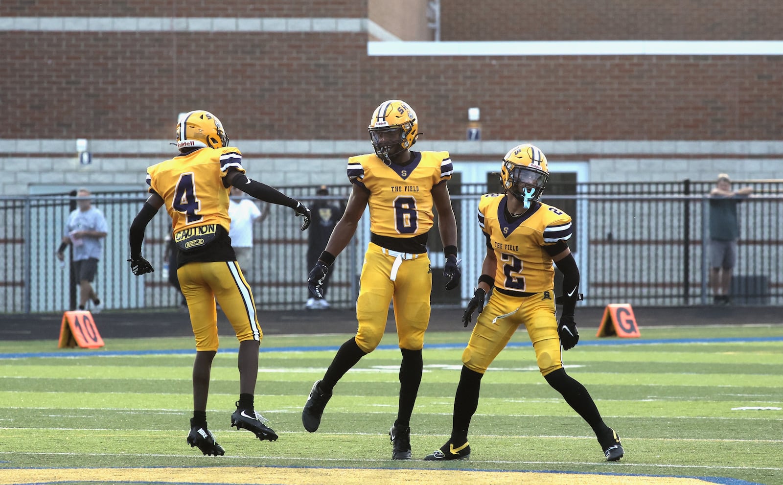 Springfield defenders (left to right) Sincere' Keyes, Taj Powell and Quenta Wafer Jr celebrate after recovering a fumble against Winton Woods on Friday, Aug. 23, 2024, in Springfield. David Jablonski/Staff