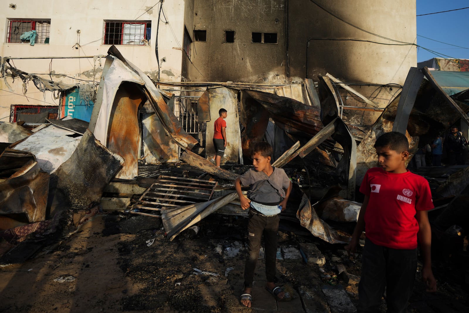 Palestinians look at the damage after an Israeli strike hit a tent area in the courtyard of Al Aqsa Martyrs hospital in Deir al Balah, Gaza Strip, Monday, Oct. 14, 2024. (AP Photo/Abdel Kareem Hana)