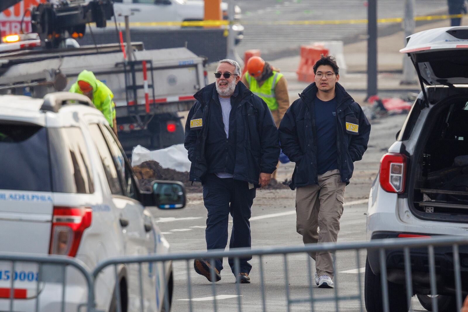 NTSB employees walk through the scene of medical jet crash Monday morning Feb. 3, 2025, in Philadelphia. (Alejandro A. Alvarez/The Philadelphia Inquirer via AP)