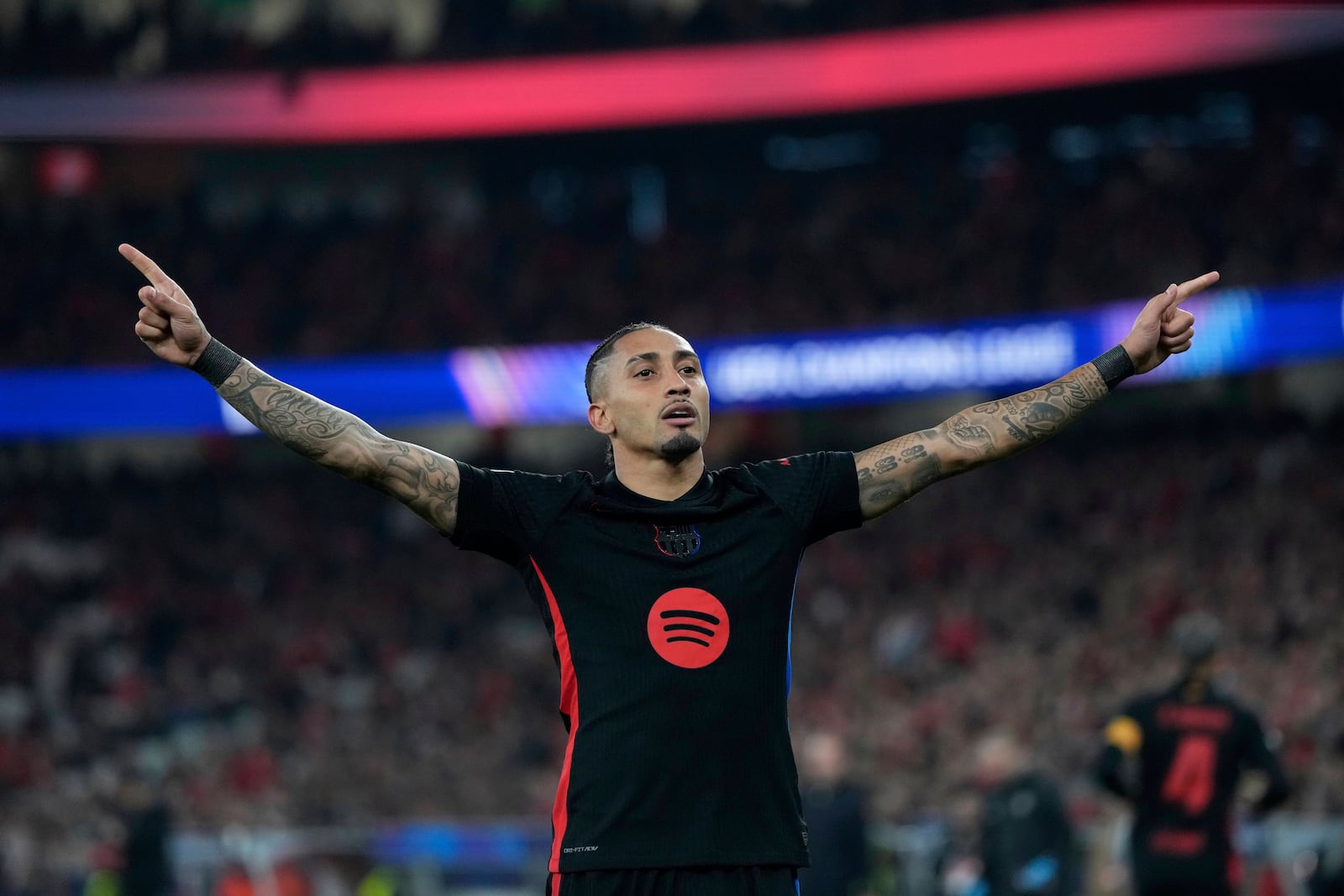 Barcelona's Raphinha celebrates after scoring his side's opening goal during the Champions League round of 16 first leg soccer match between SL Benfica and FC Barcelona at the Luz stadium in Lisbon, Wednesday, March 5, 2025. (AP Photo/Armando Franca)