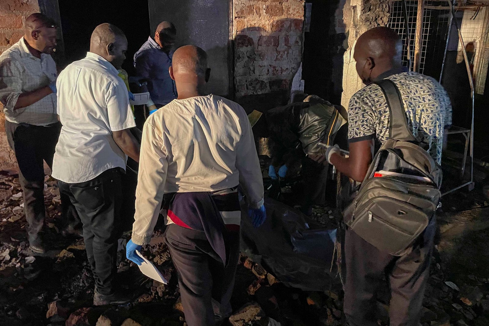 Uganda forensic officials inspect the site where a fuel truck exploded, on the outskirts of Kampala, Uganda, Tuesday, Oct. 22, 2024. (AP Photo)