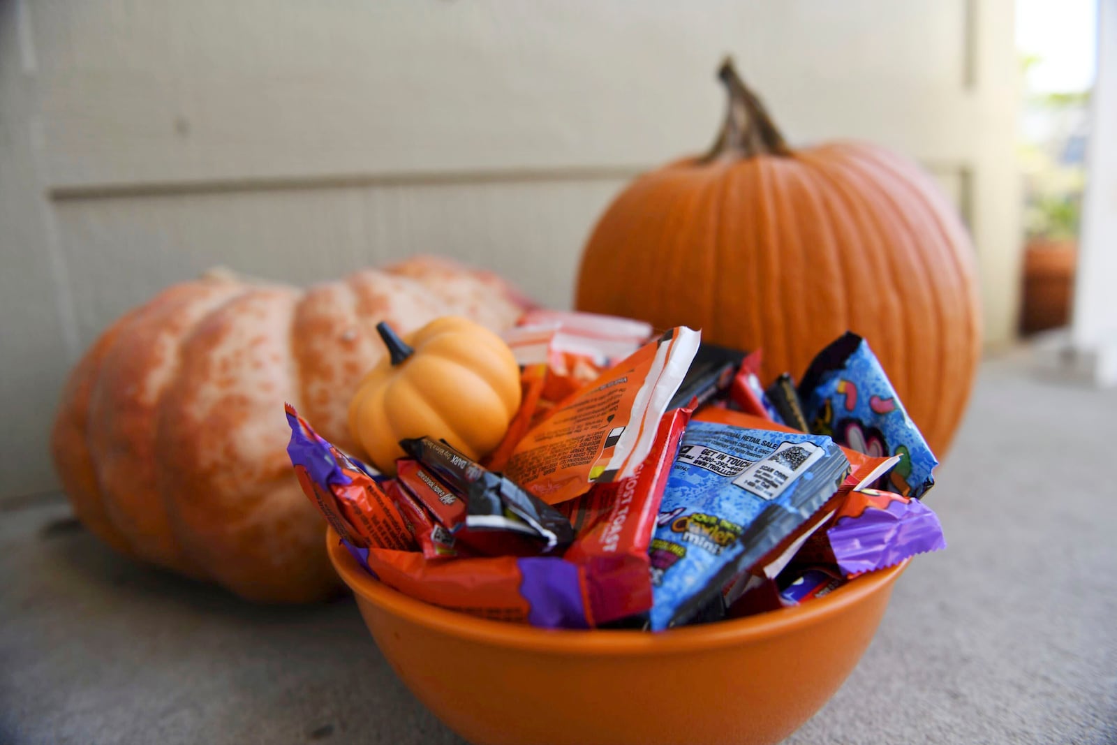 Halloween candy and pumpkins sit outside of a home Friday, Oct. 11, 2024, in St. Joseph, Mo. (AP Photo/Nick Ingram)