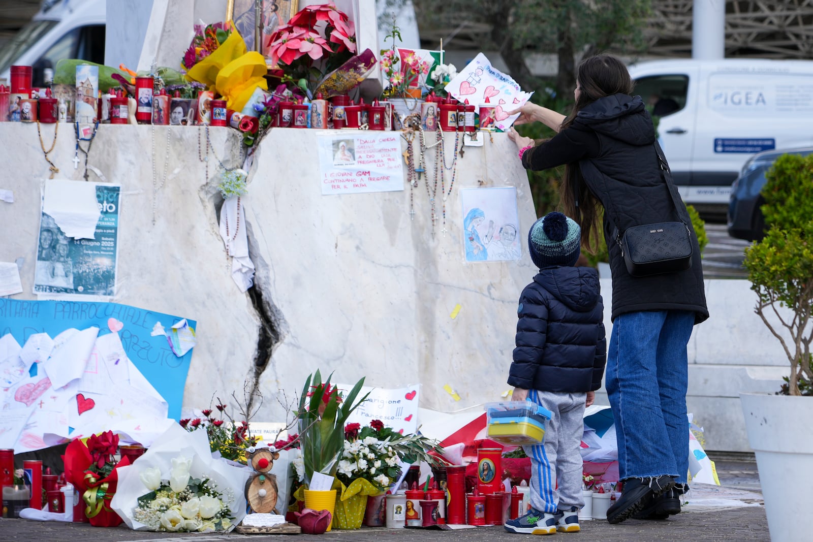 People pray for Pope Francis in front of the Agostino Gemelli Polyclinic, in Rome, Saturday, March 15, 2025, where the Pontiff is hospitalized since Feb. 14. (AP Photo/Andrew Medichini)