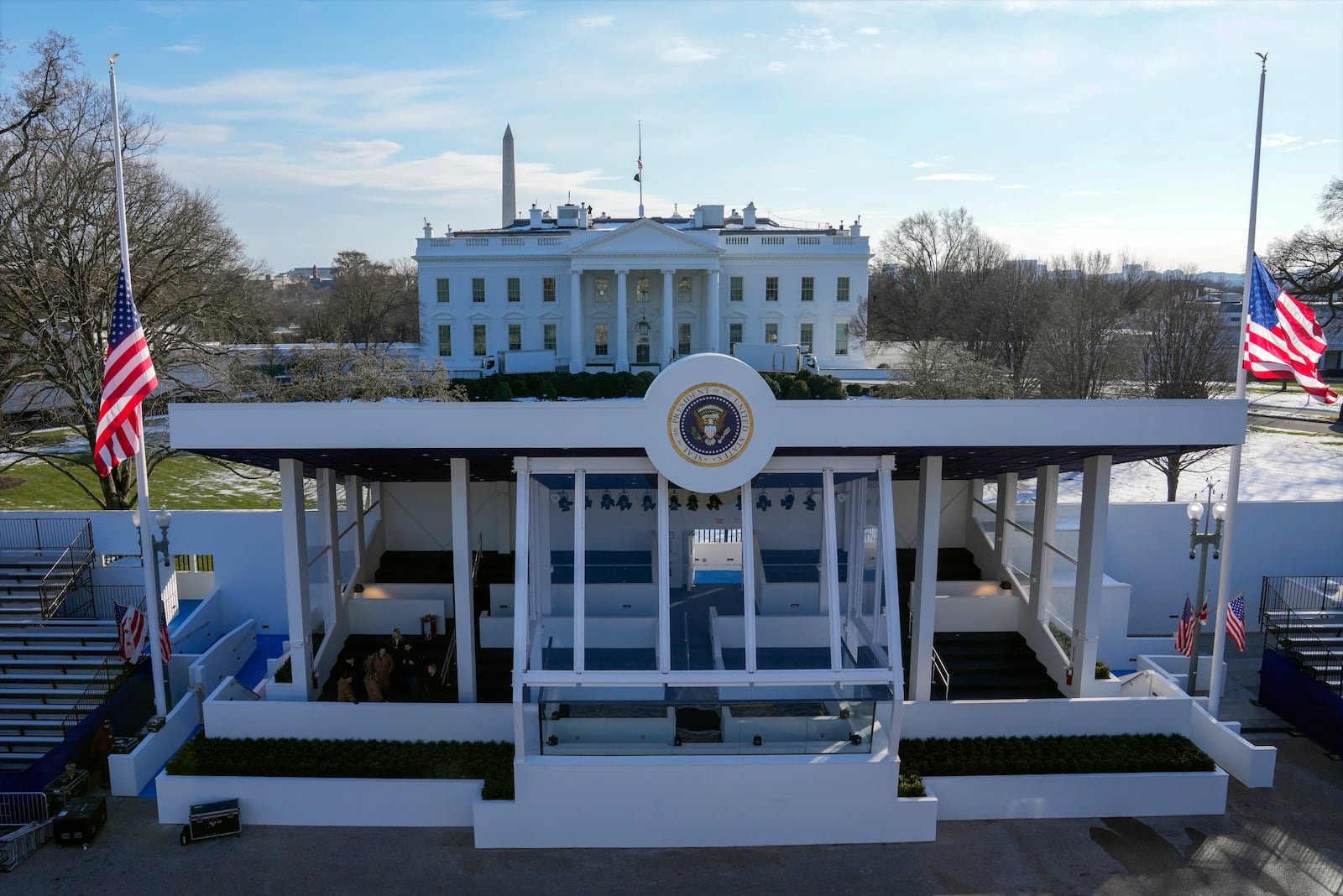 Workers continue with the finishing touches on the presidential reviewing stand on Pennsylvania outside the White House Thursday, Jan. 16, 2025, in Washington, ahead of President-elect Donald Trump's inauguration. (Jon Elswick via AP)