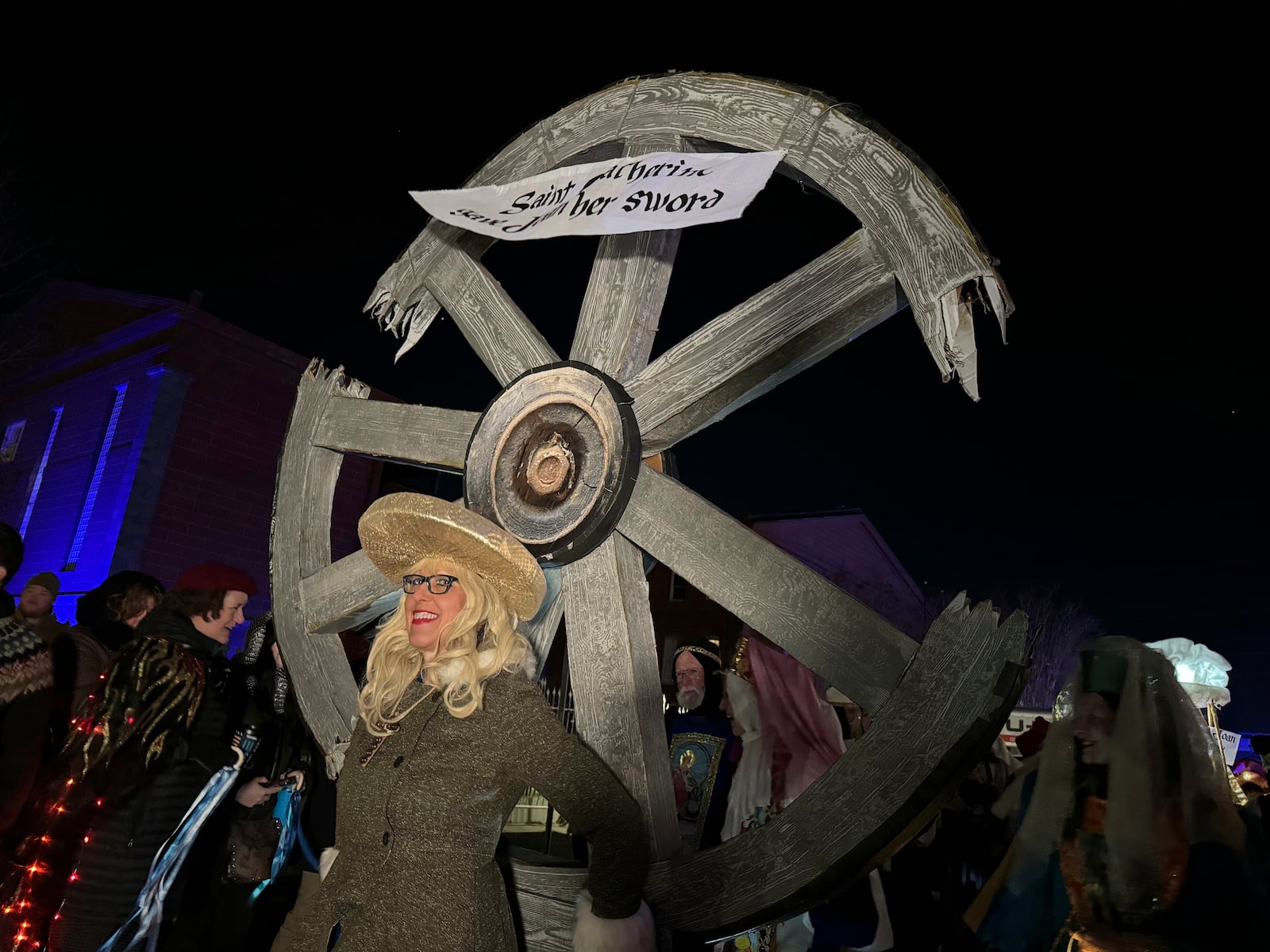 A marcher in the Joan of Arc parade carries a wheel symbolizing the sainthood of St. Catherine at the Joan of Arc parade on Monday, Jan. 6, 2025, in New Orleans. (AP Photo/Jack Brook)